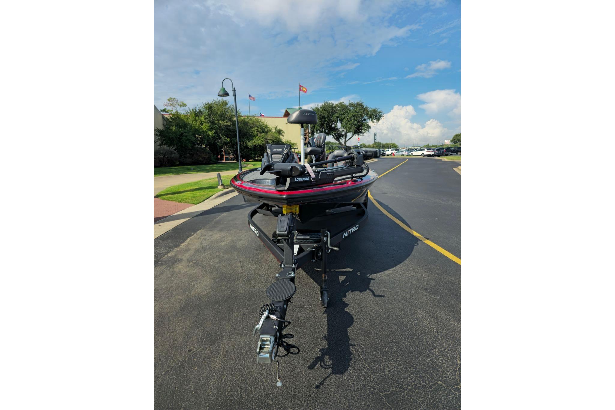 2024 Nitro Z19 boat on a trailer, parked on a sunny street.