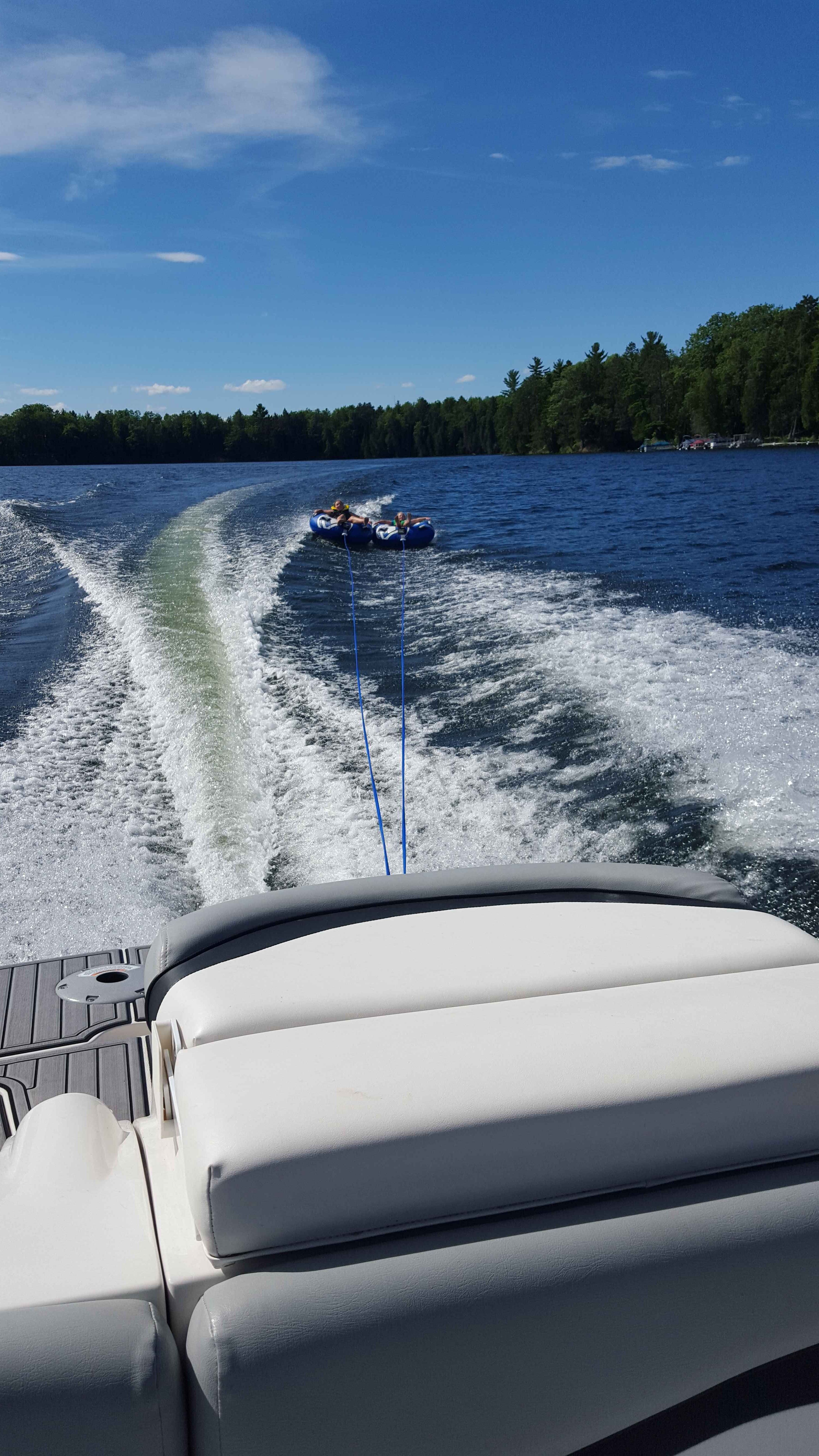 Starcraft 2000 boat towing tubes on a lake, 2015.