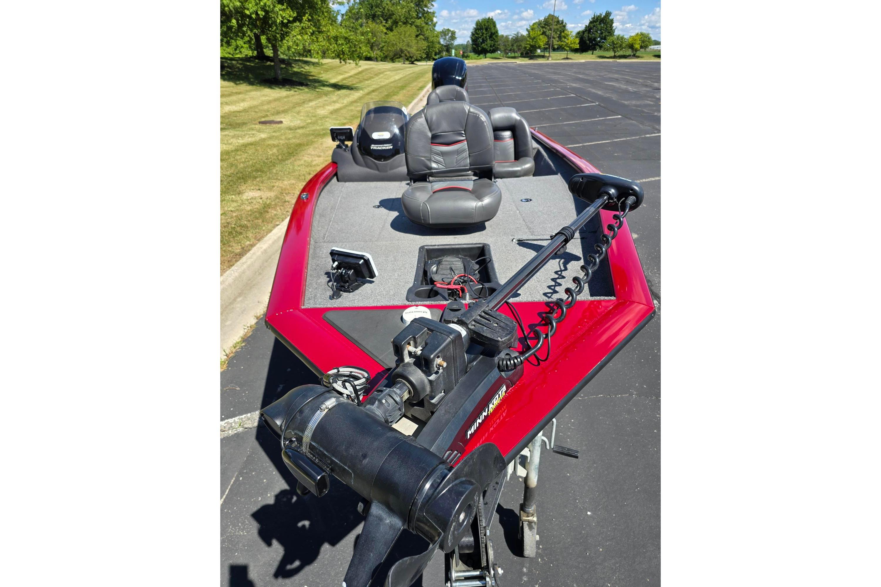 2021 Tracker Pro Team 175 TXW boat with red exterior, parked on pavement.
