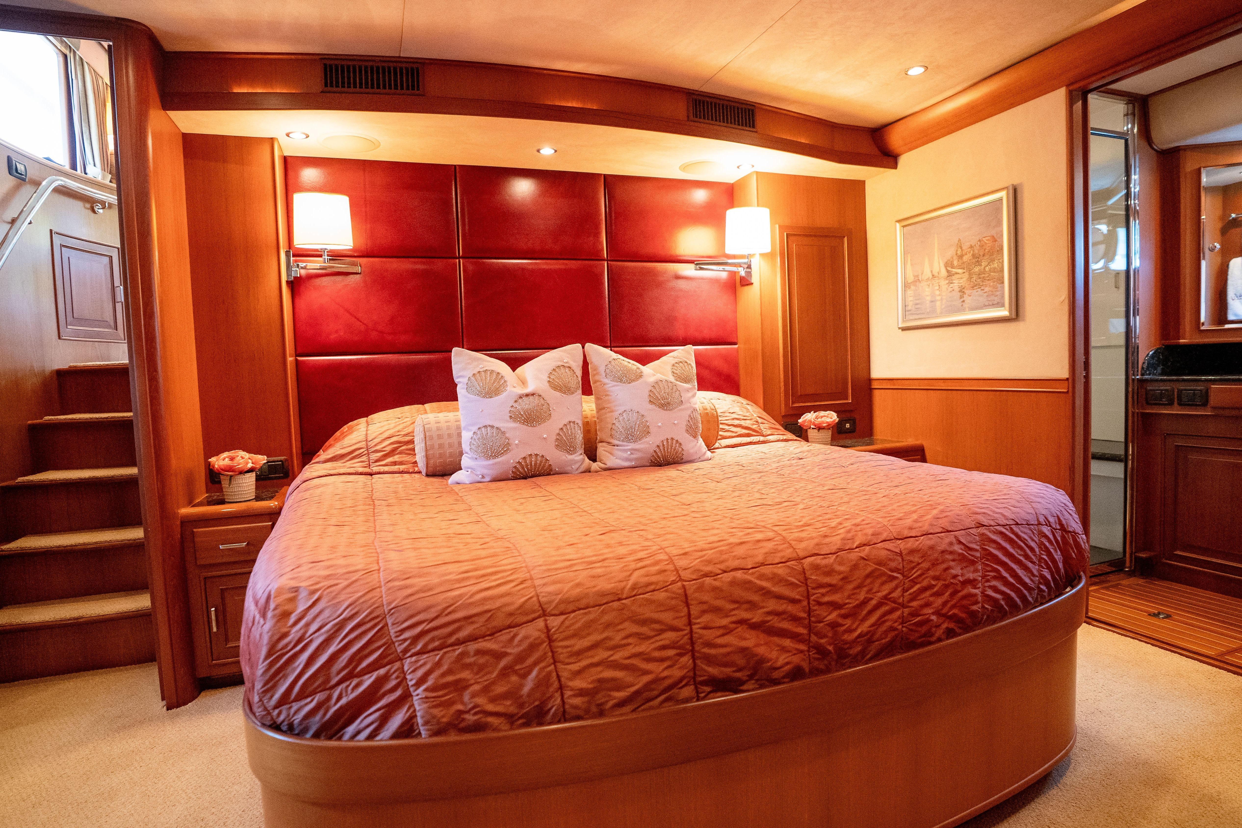 Luxurious bedroom interior on a 2006 Fleming 75 yacht, featuring elegant wood paneling.