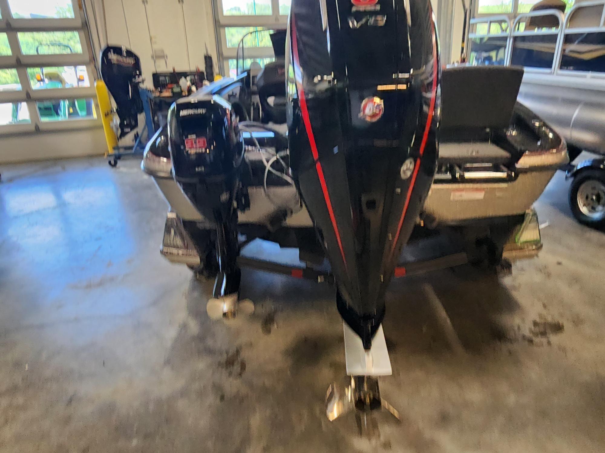 2025 Ranger 1880MS boat with dual Mercury outboard motors in a garage setting.