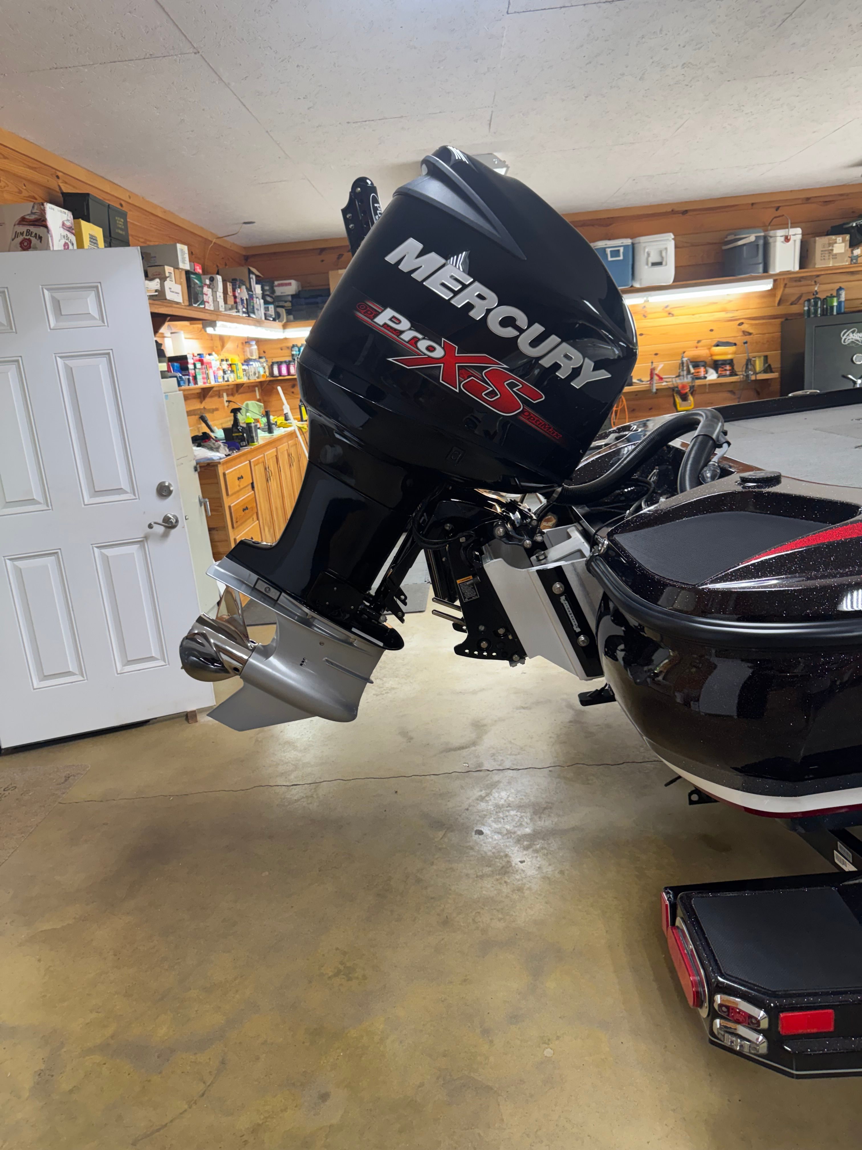 A Mercury Pro XS outboard motor is mounted on a boat inside a garage.