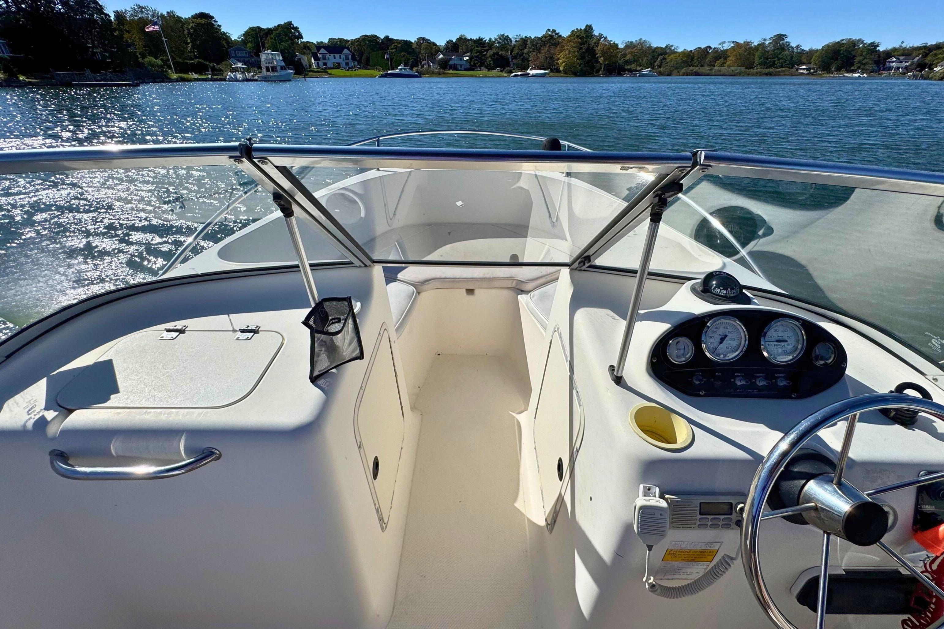 2002 Sea Hunt Escape 200 boat interior with steering wheel, dashboard, and lake view.
