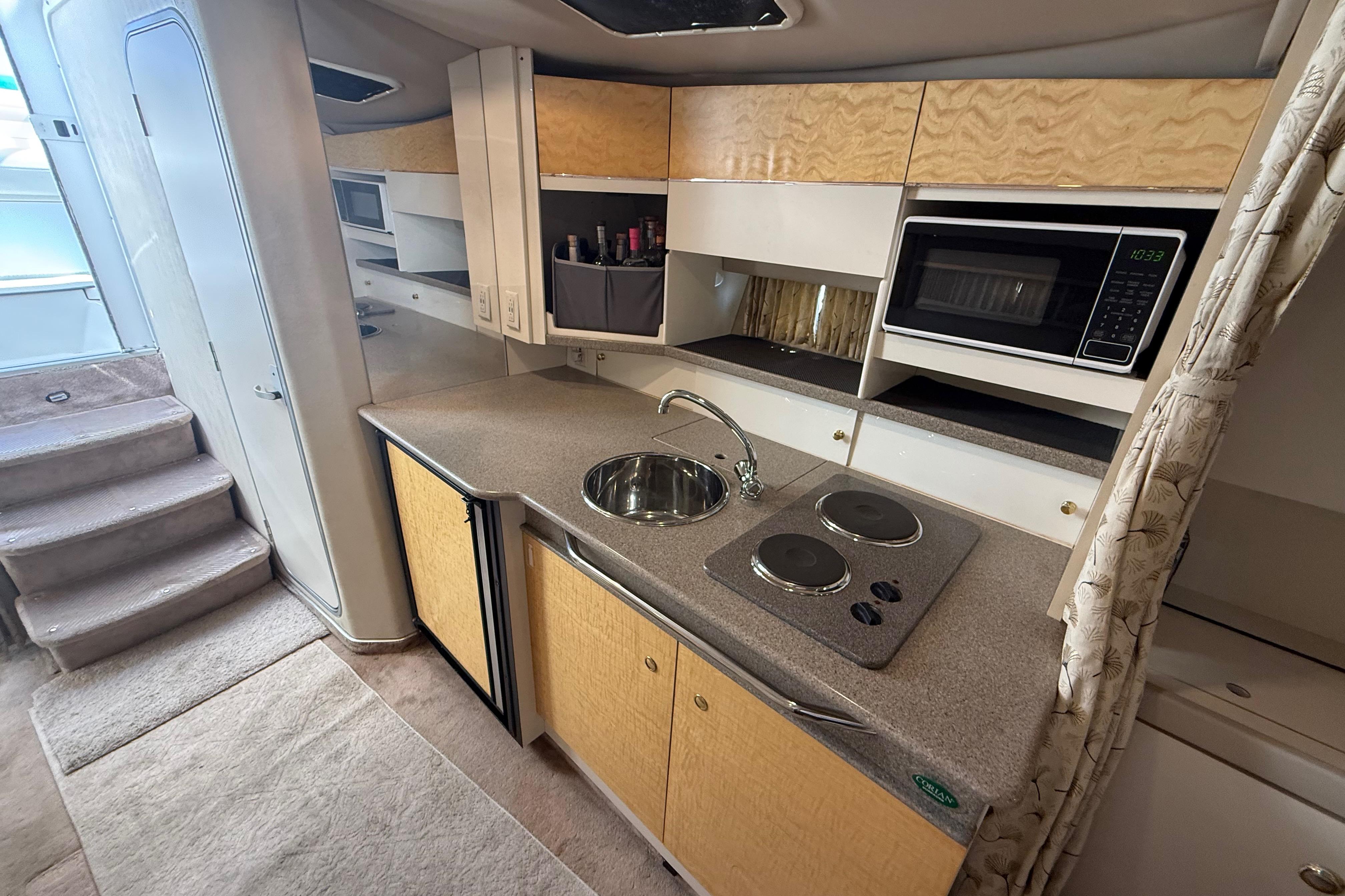 Interior of a 1999 Formula 34 Performance Cruiser, featuring a compact kitchen with modern amenities.