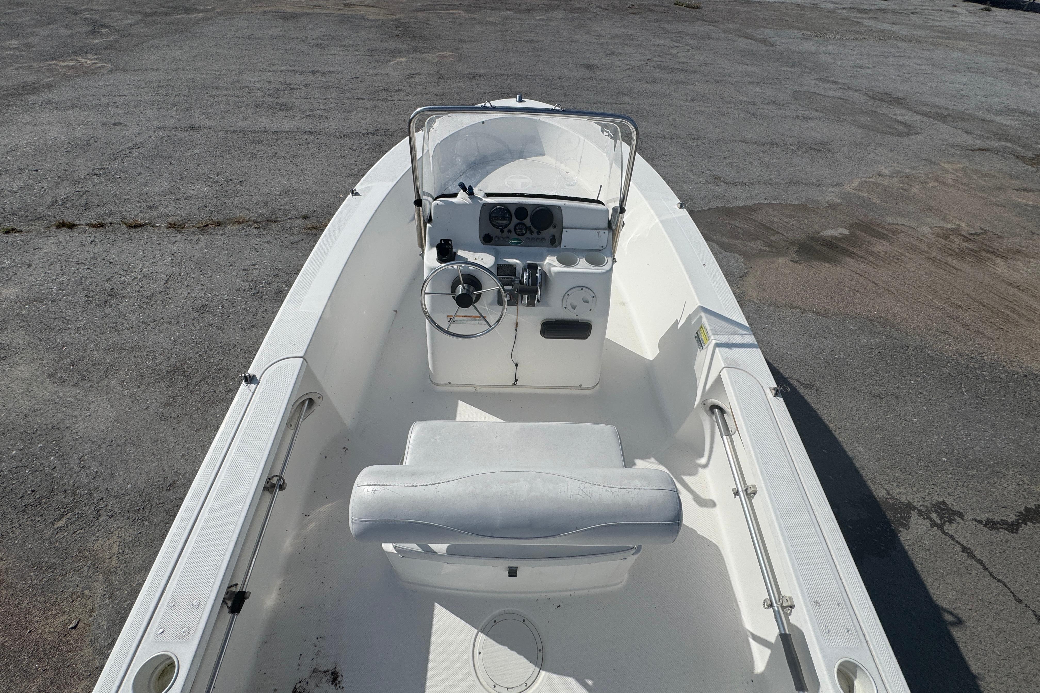 2007 Trophy 1703 Center Console boat with steering wheel and seating, parked on pavement.