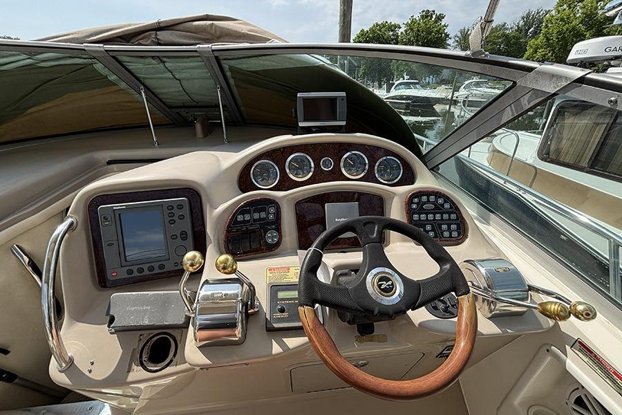 Cockpit of 2002 Sea Ray Sundancer 320 with steering wheel and navigation controls.