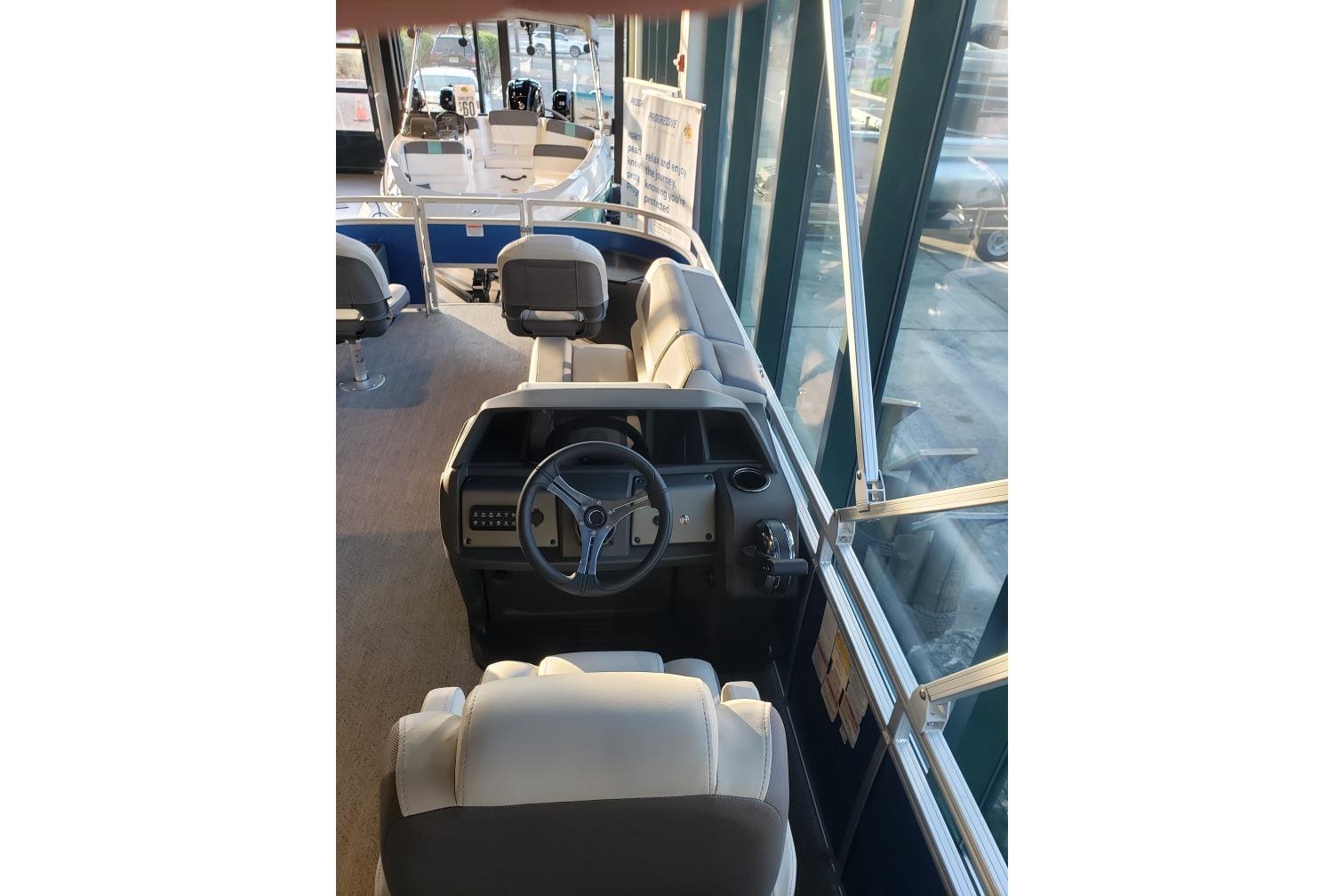 2026 Sun Tracker Fishin' Barge 20 DLX interior with steering wheel and seating.