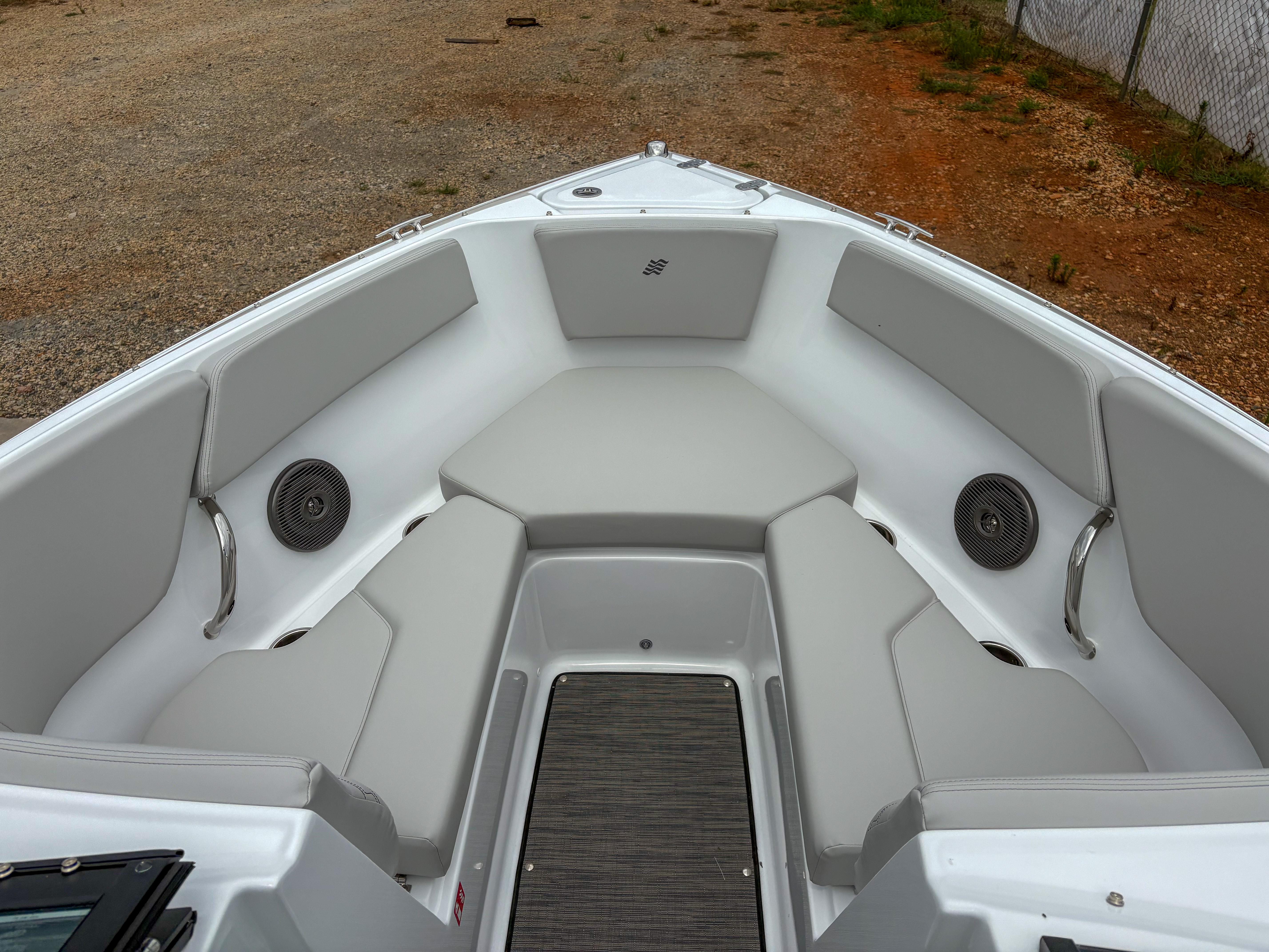 2026 Four Winns H2 Freedom boat interior with gray seating and speakers.