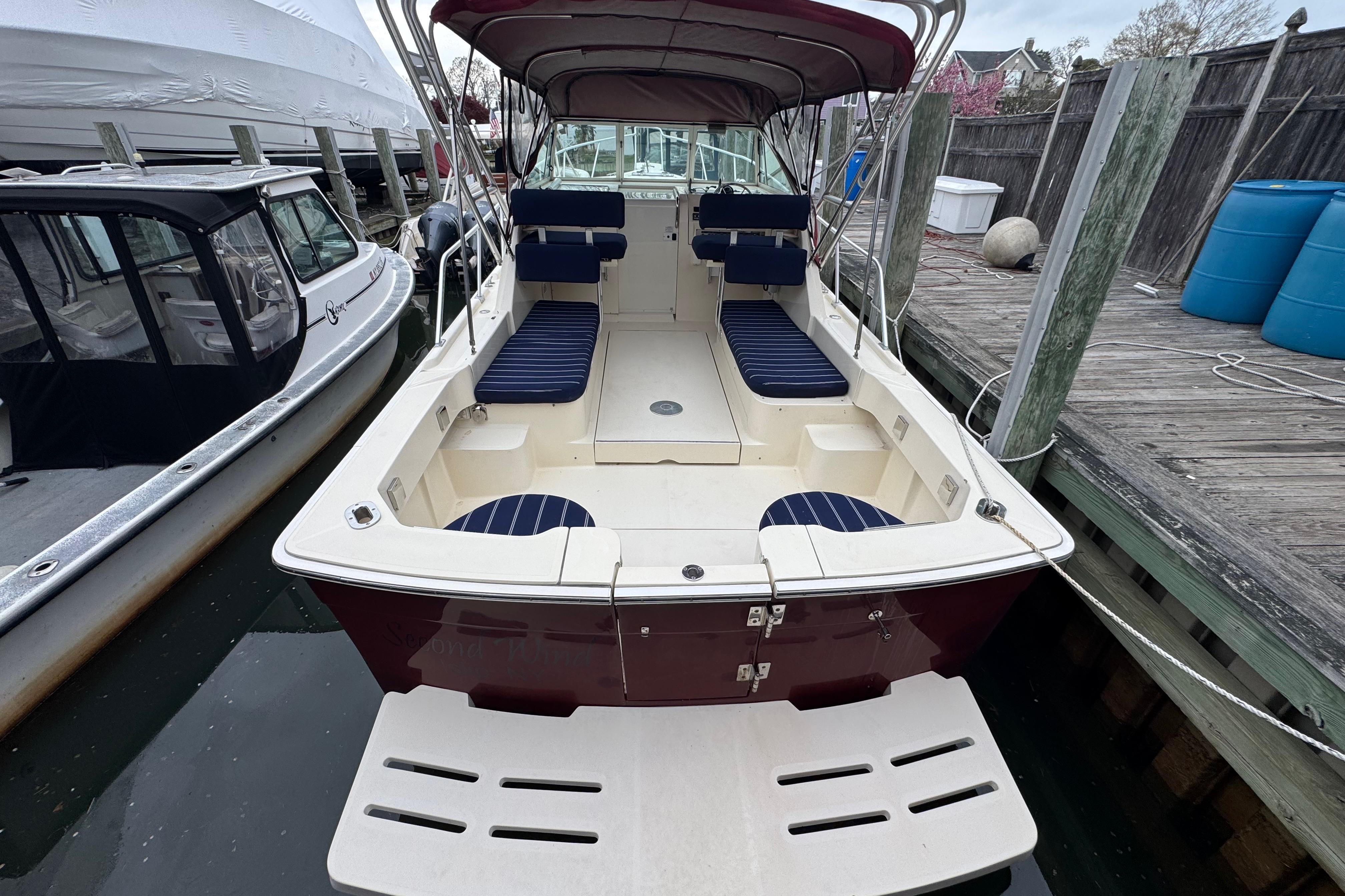 2001 Mainship Pilot 30 boat docked, featuring spacious seating and canopy.