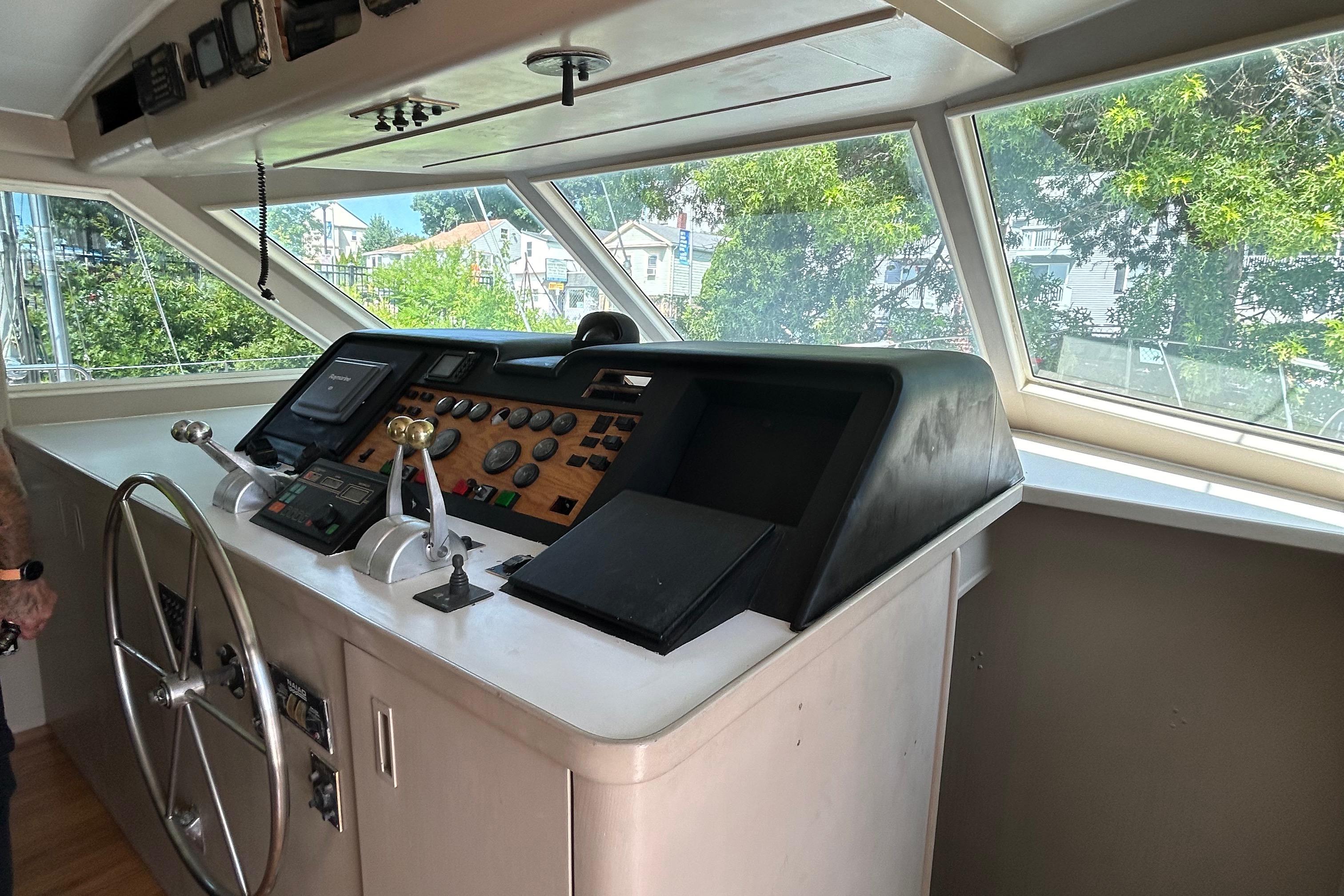 1991 Hatteras Cockpit Motor Yacht helm with steering wheel and control panel.