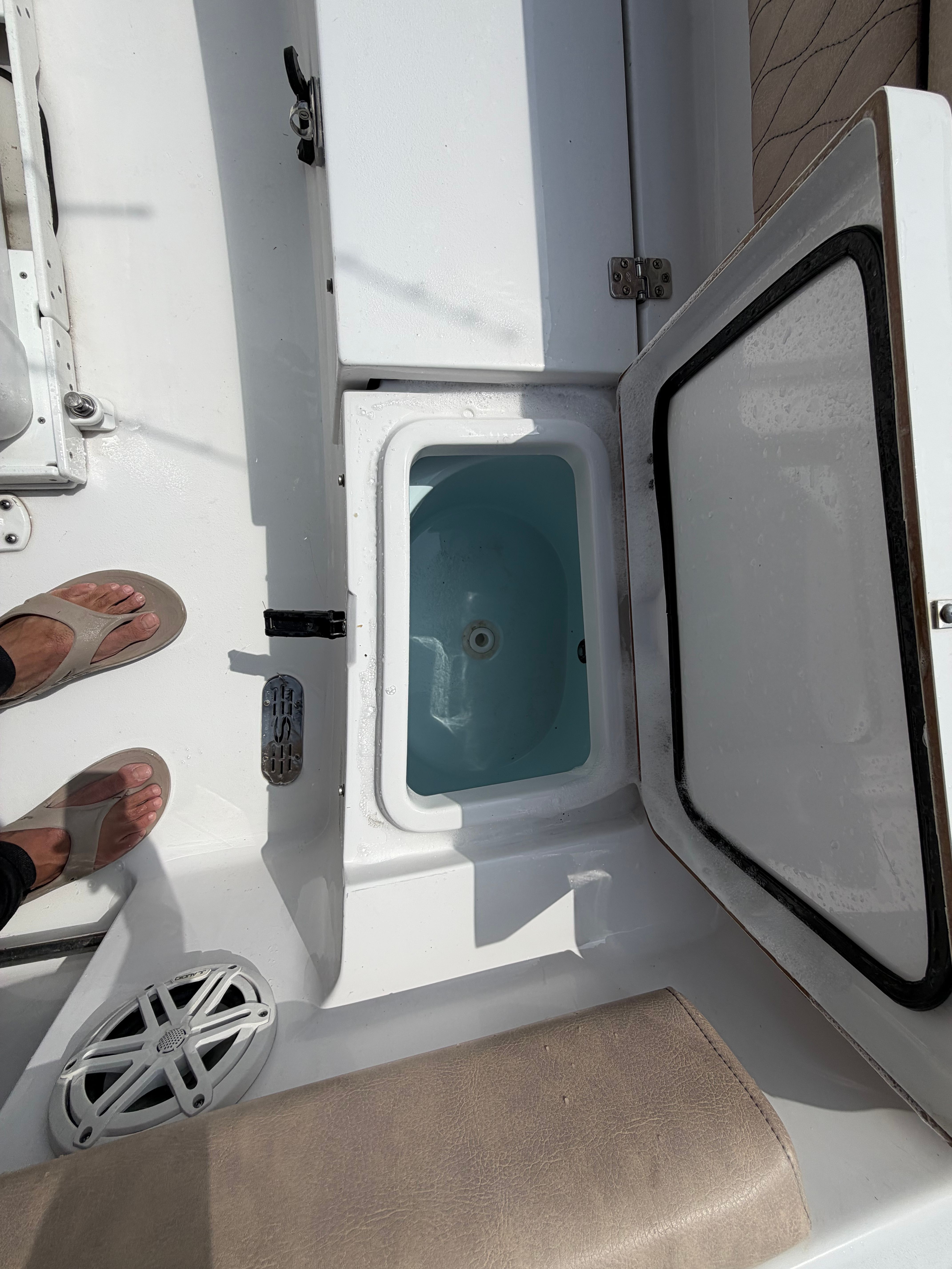 An open storage compartment on a 2020 Sportsman Heritage 211 Center Console boat.