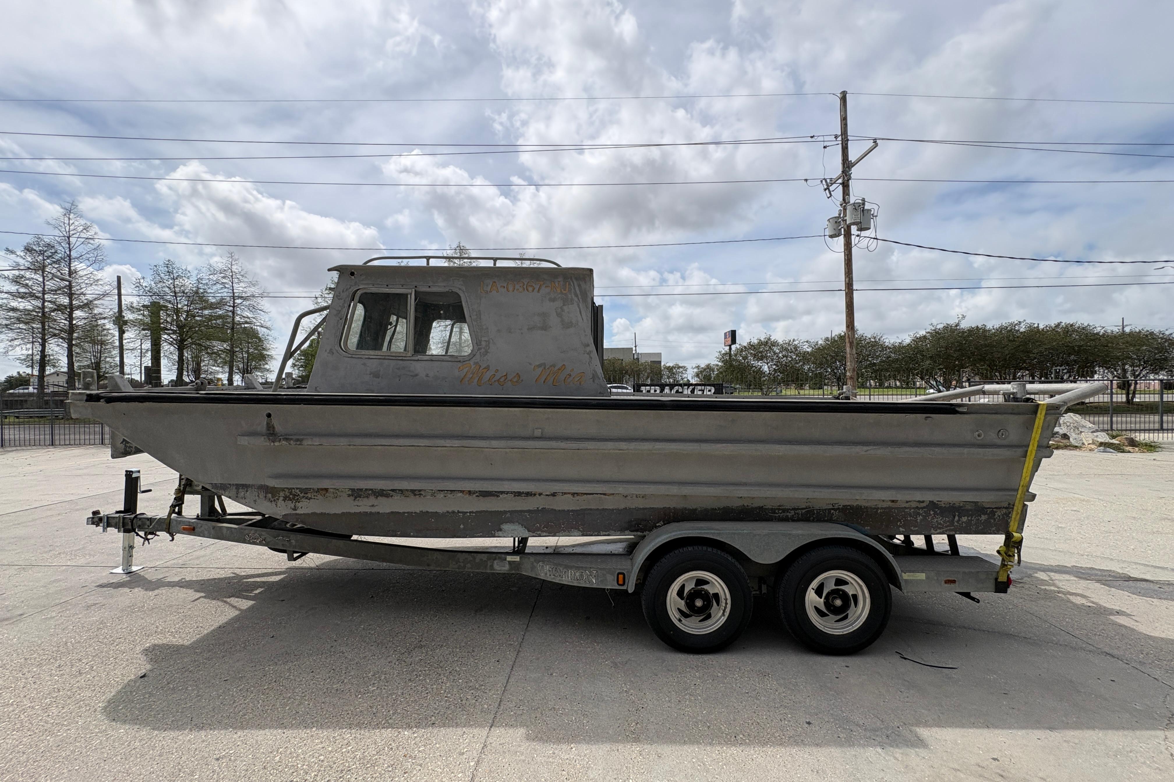 1972 Custom 23' work/push boat on trailer, parked outdoors under cloudy sky.