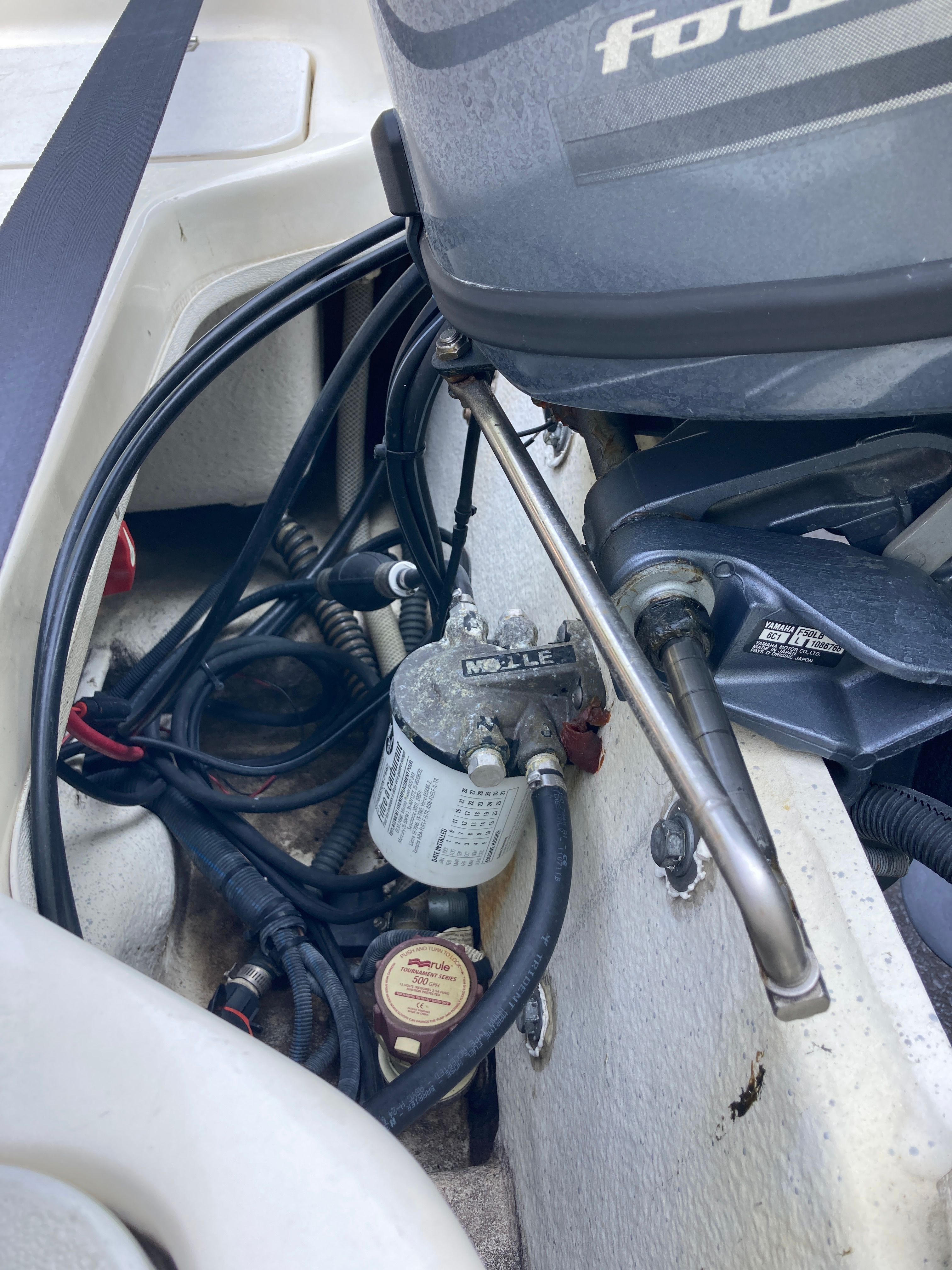 Close-up of a boat's engine compartment with cables and a fuel filter.