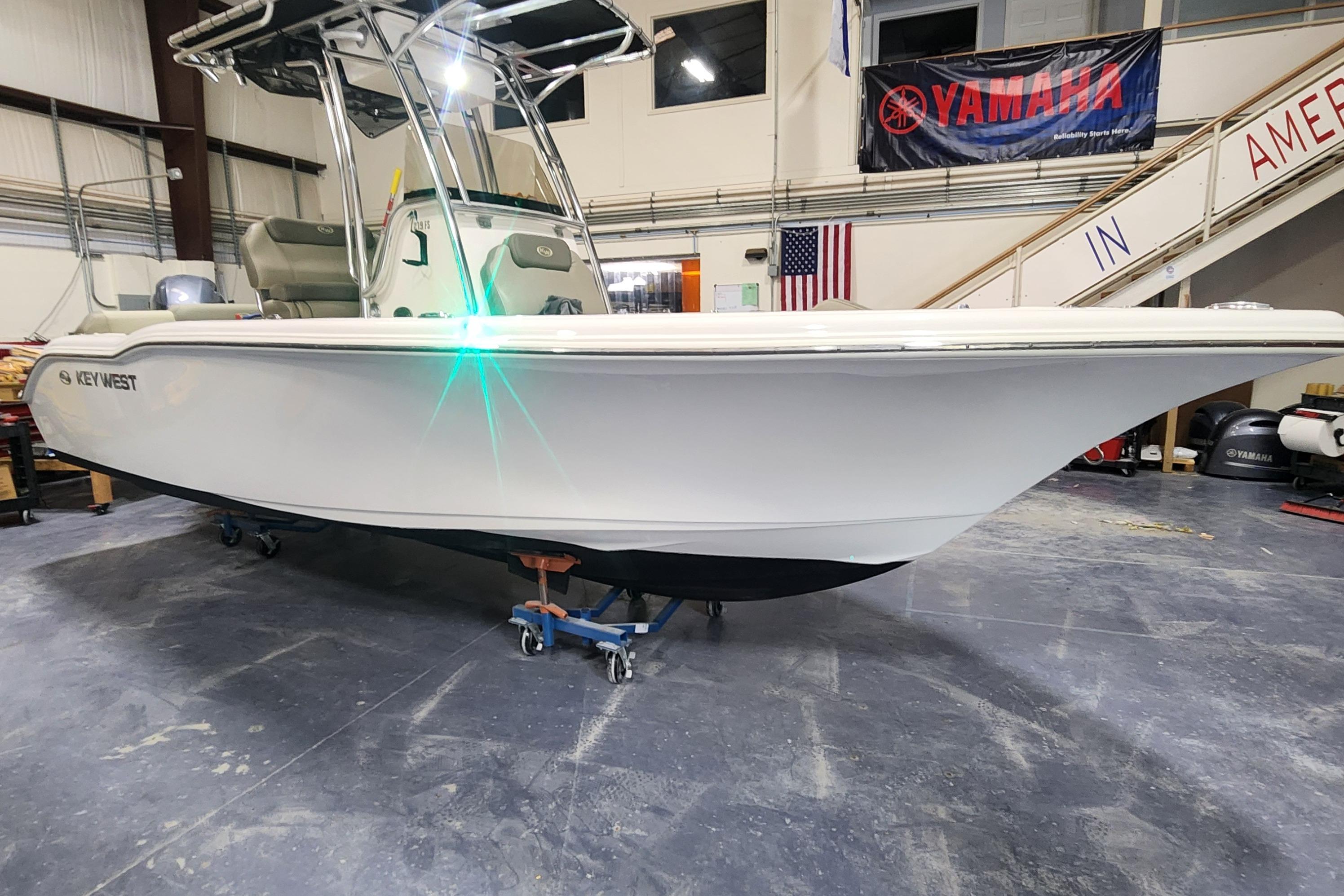 2023 Key West 219 FS boat in showroom, featuring sleek design and Yamaha banner.