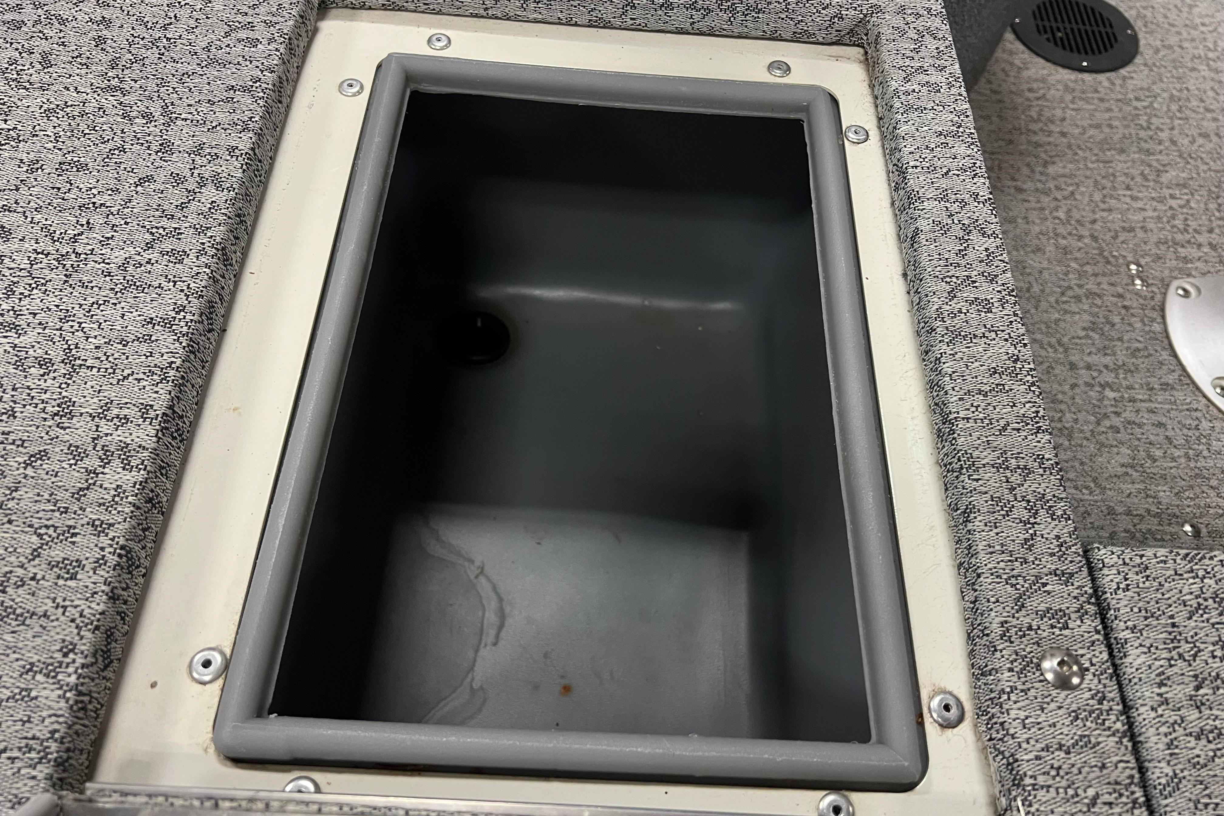 Storage compartment in 2022 Tracker Pro Guide V-16 WT boat, featuring gray interior and textured surface.