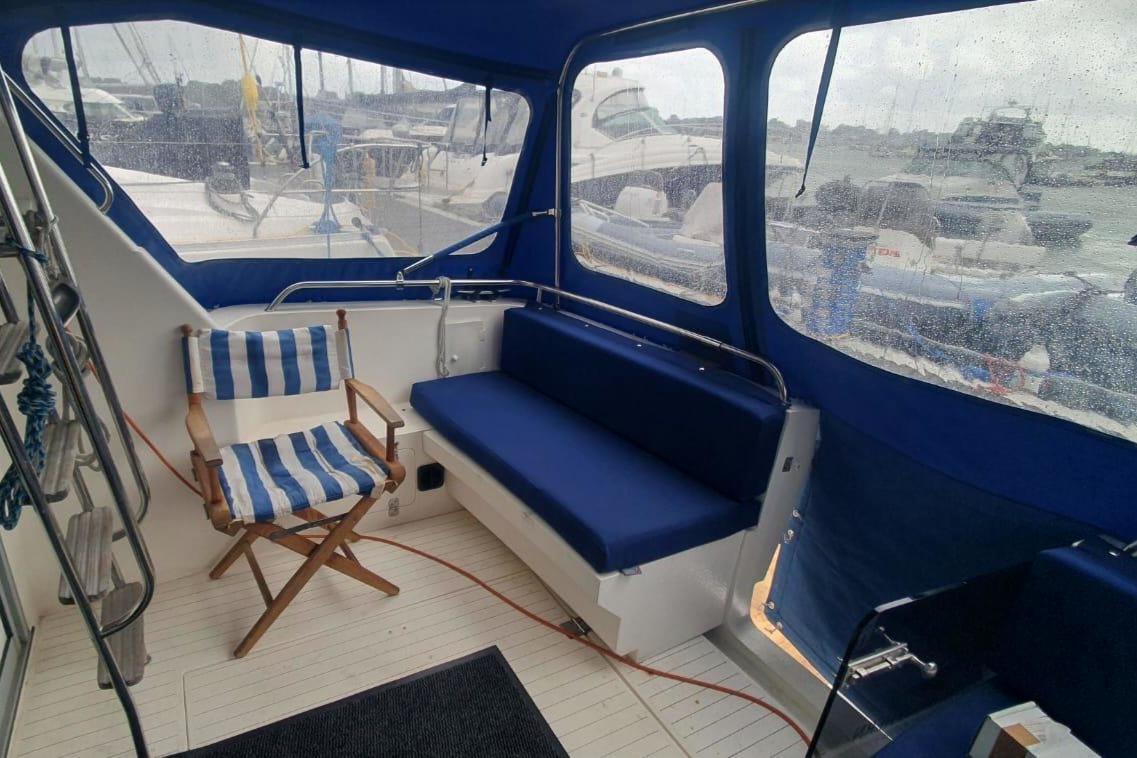 Interior of 1989 Princess 35 yacht with blue seating and striped chair.