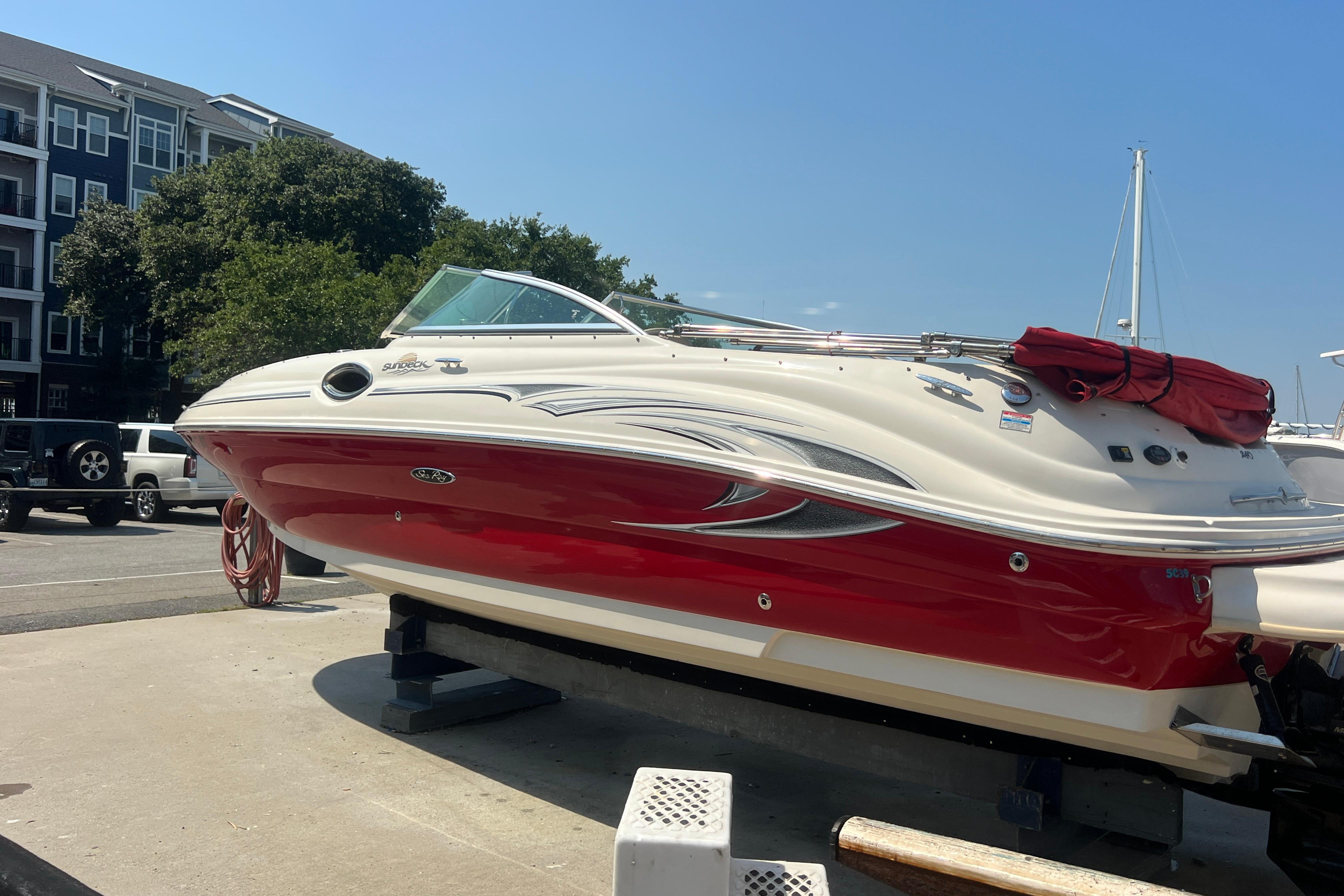 2005 Sea Ray 240 Sundeck boat with red and white exterior on a trailer.