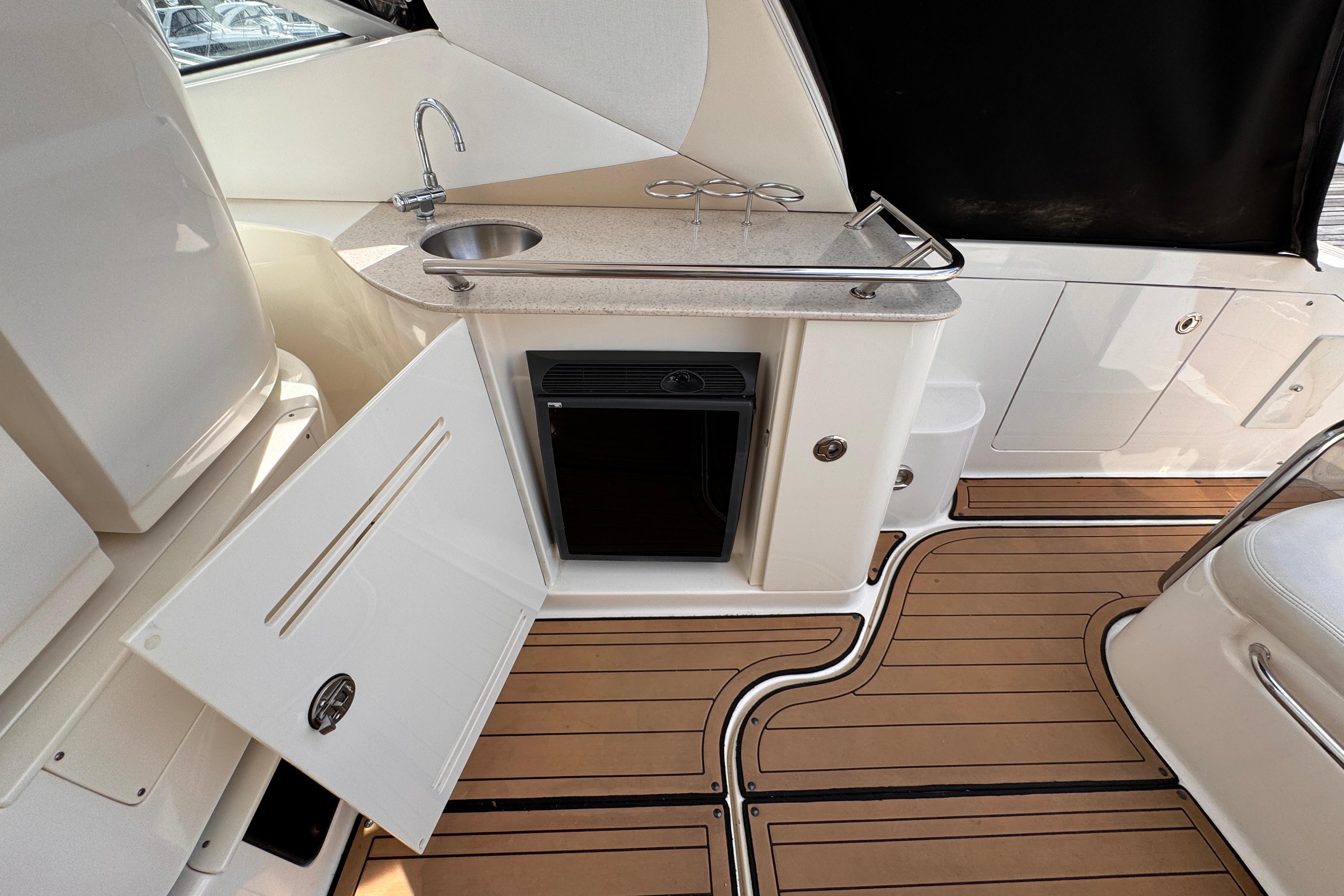 2008 Sea Ray Sundancer 350 yacht interior with kitchenette, sink, and wooden flooring.