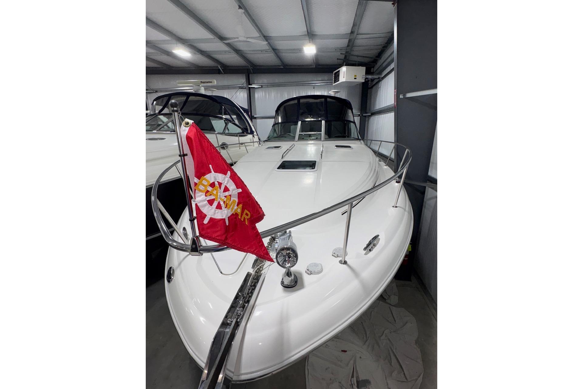 2001 Sea Ray 340 Sundancer yacht in storage, featuring a red flag on the bow.