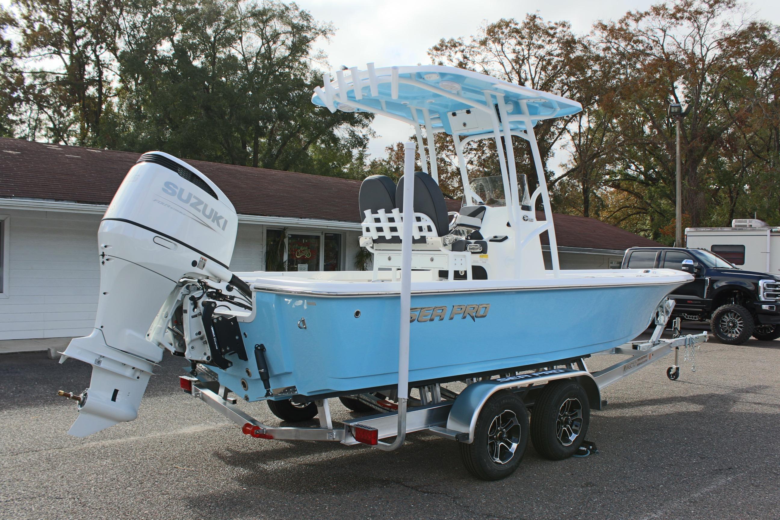 2025 Sea Pro 230 Bay boat with Suzuki engine on trailer, parked outdoors.