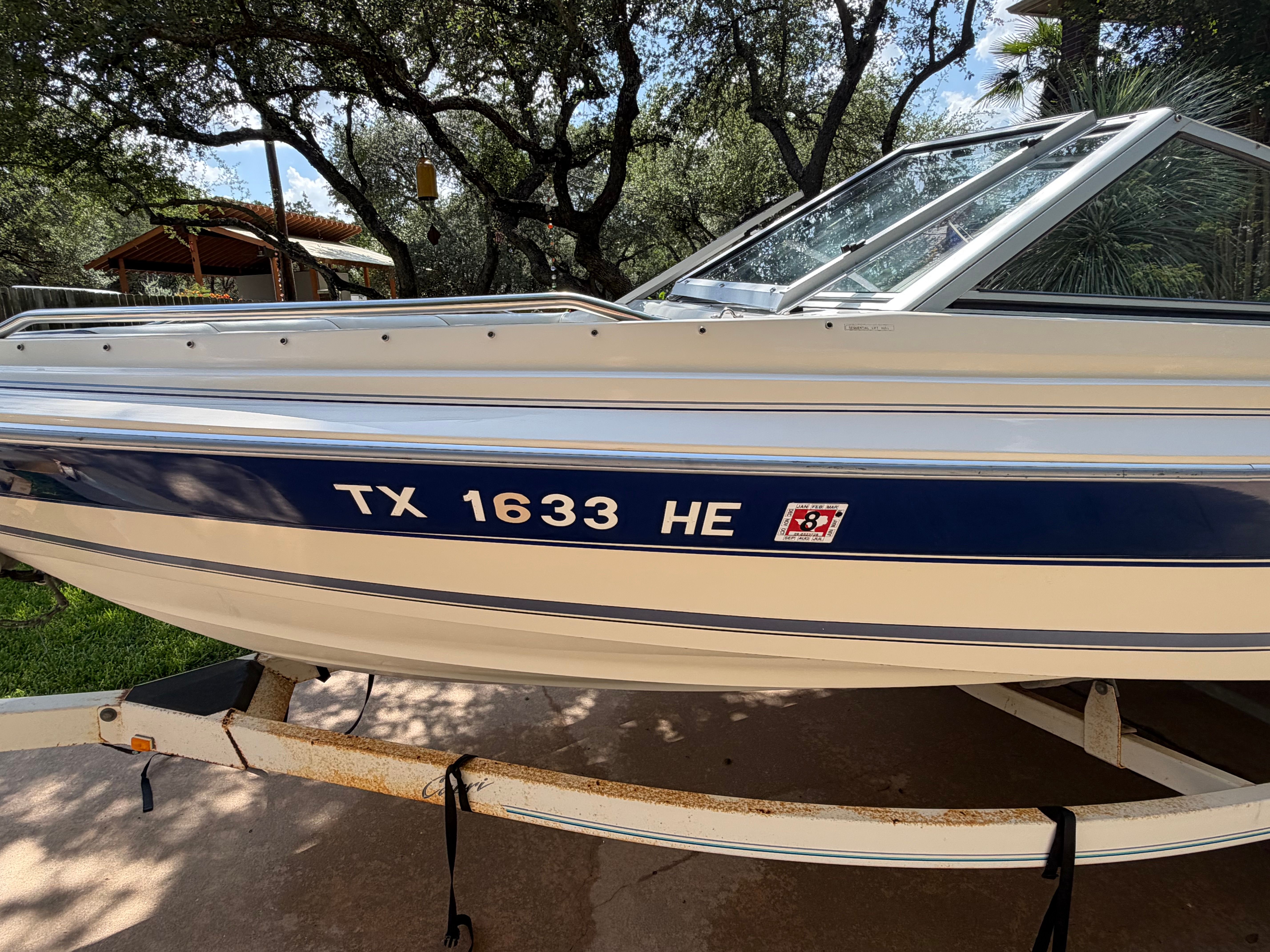 A 1994 Bayliner CAPRI on a trailer, surrounded by trees.