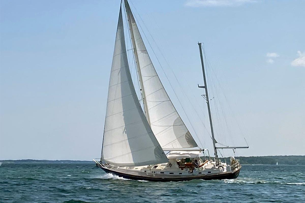 Sailing yacht Little Harbor 53 from 1988 gliding on open water under clear skies.