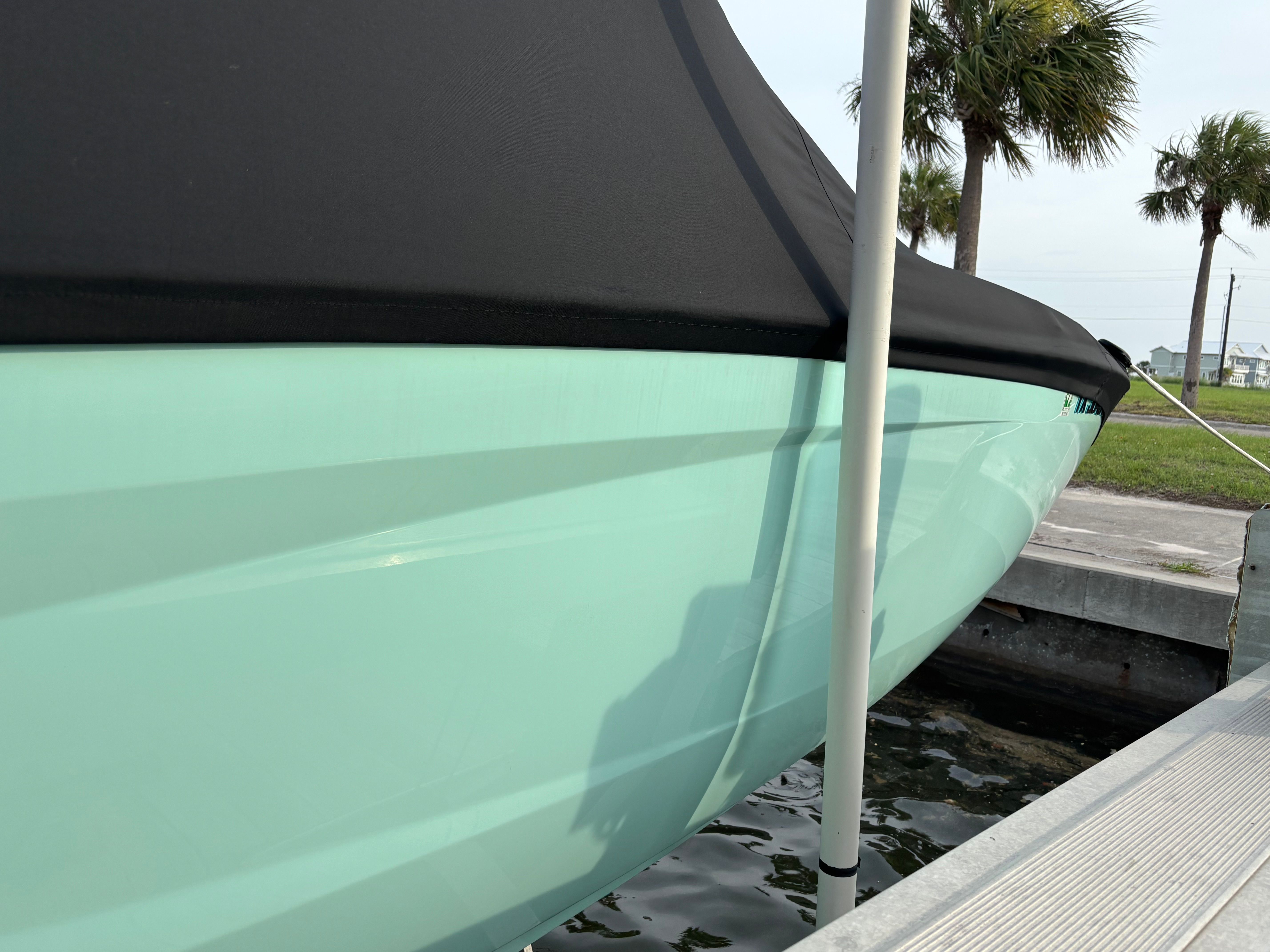 A 2024 Yamaha AR250 boat is in the water, partially covered with a black cover.