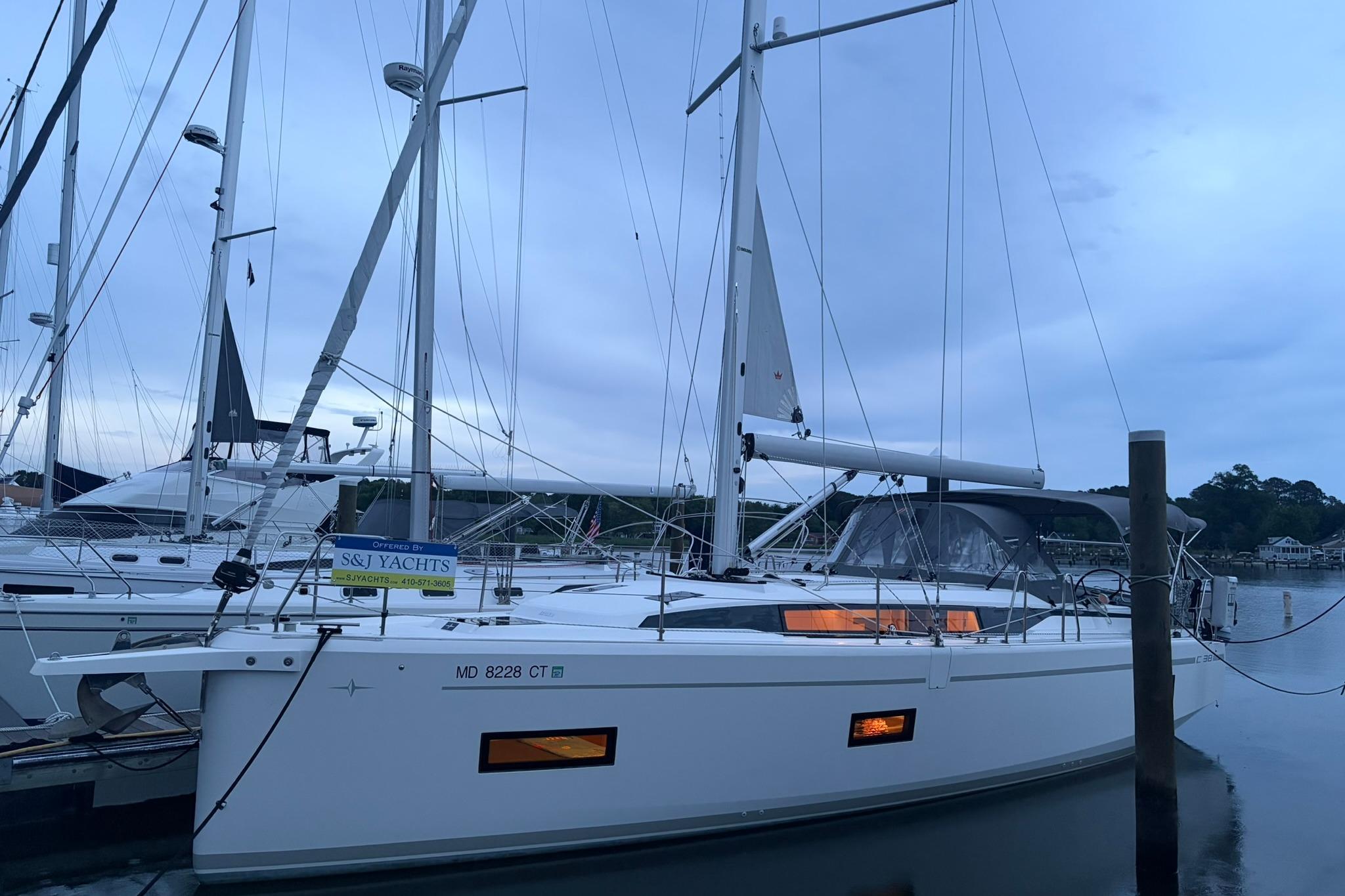 2022 Bavaria C38 yacht docked at marina during twilight.