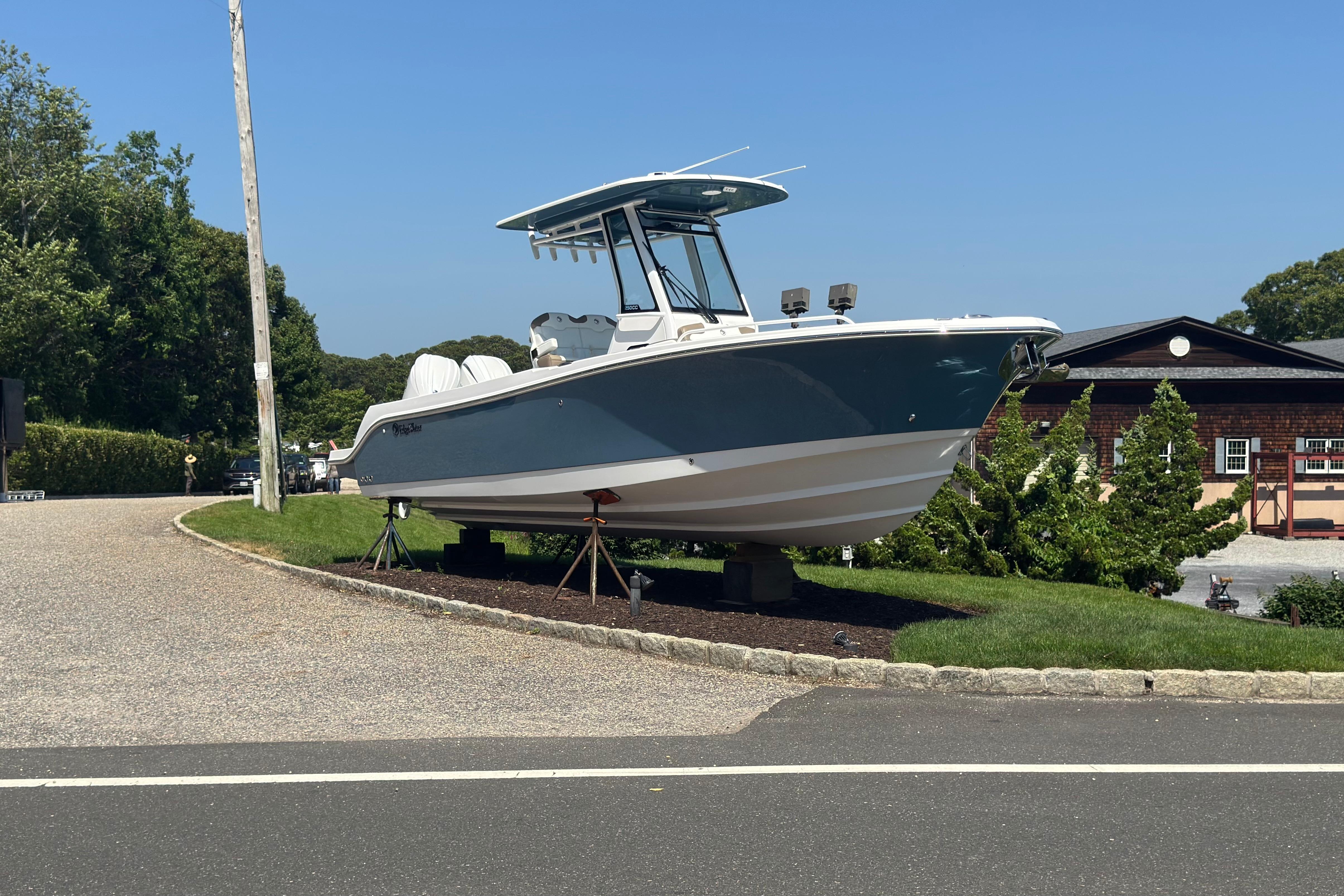 2026 Edgewater 250CC boat displayed on stands in a residential area.