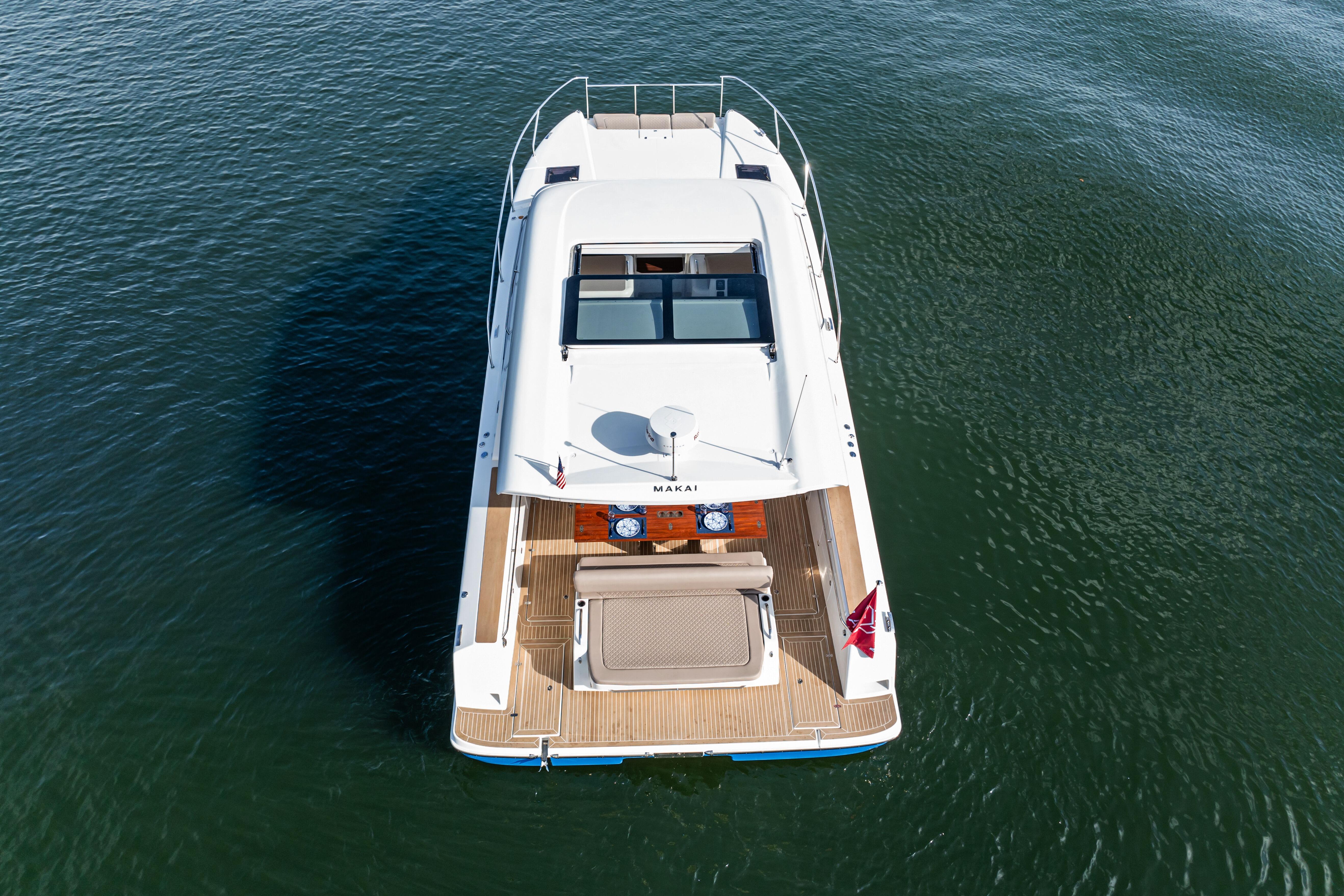 Aerial view of 2025 Makai M37 yacht on calm water.