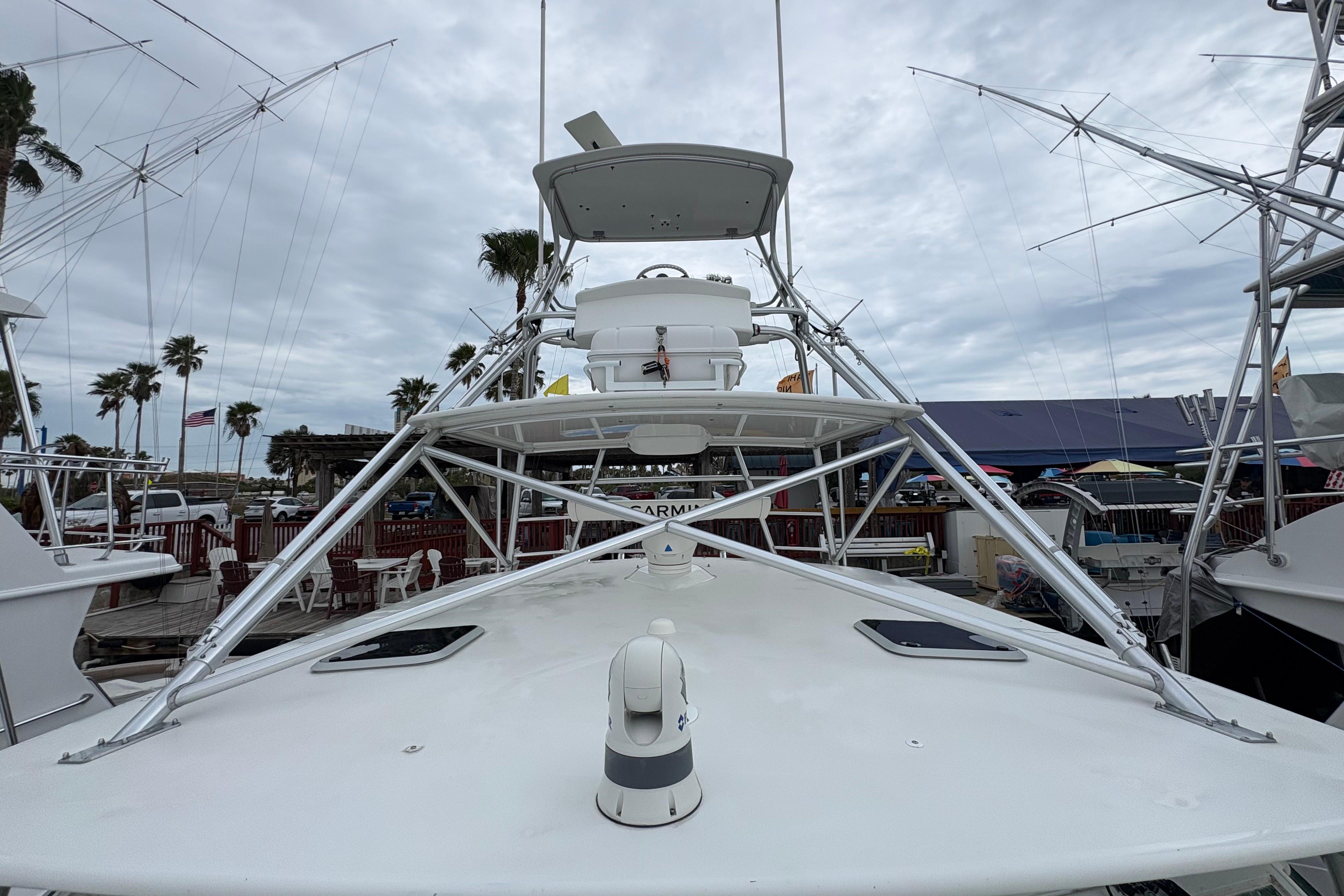 2004 Cabo 40 Hardtop Express boat docked, featuring a sleek design and tower structure.
