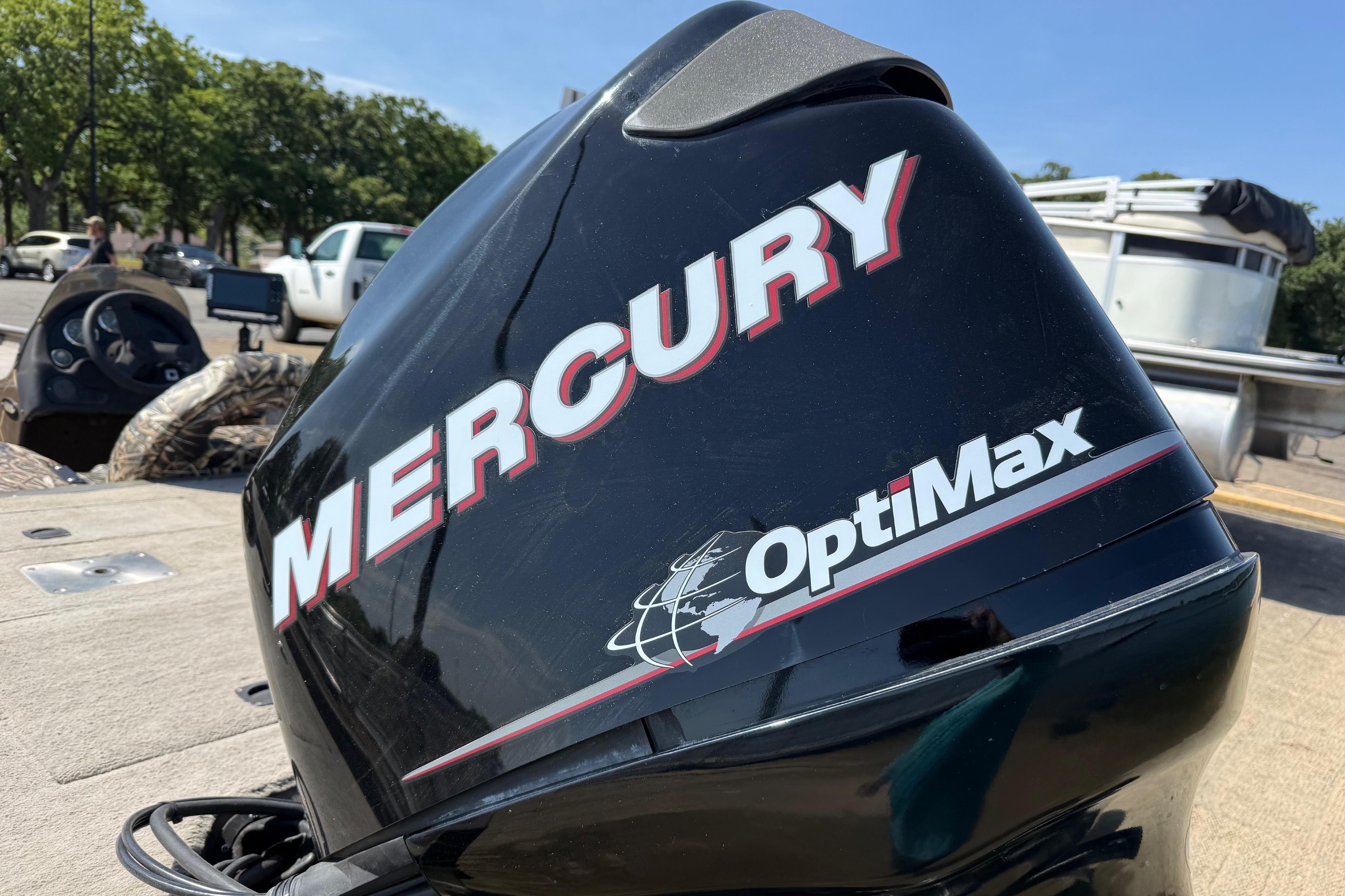 Mercury OptiMax engine on 2010 SeaArk Stealth 190 boat, parked outdoors.