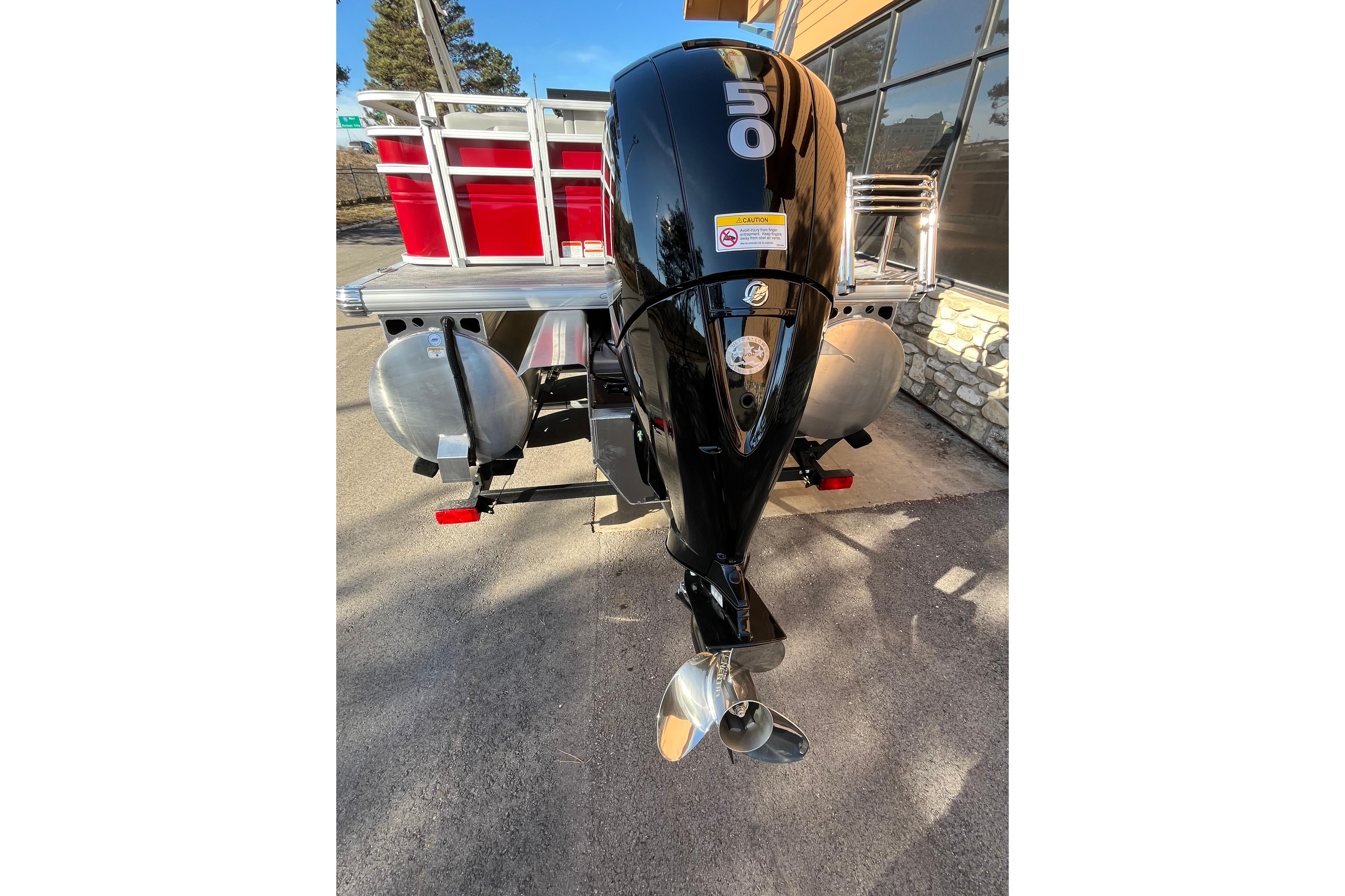 2026 Sun Tracker SportFish 22 XP3 boat with powerful outboard motor, parked outdoors.