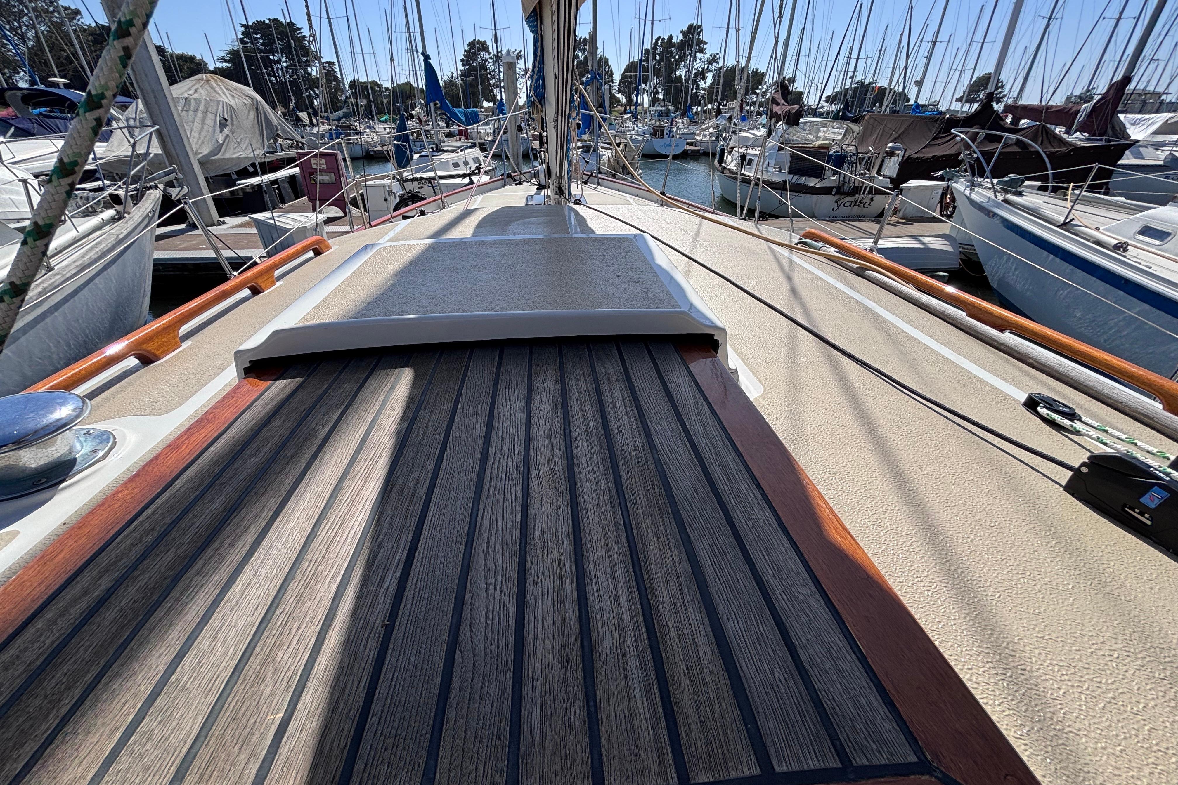1978 Swift 33 sailboat deck view in marina, surrounded by other boats.