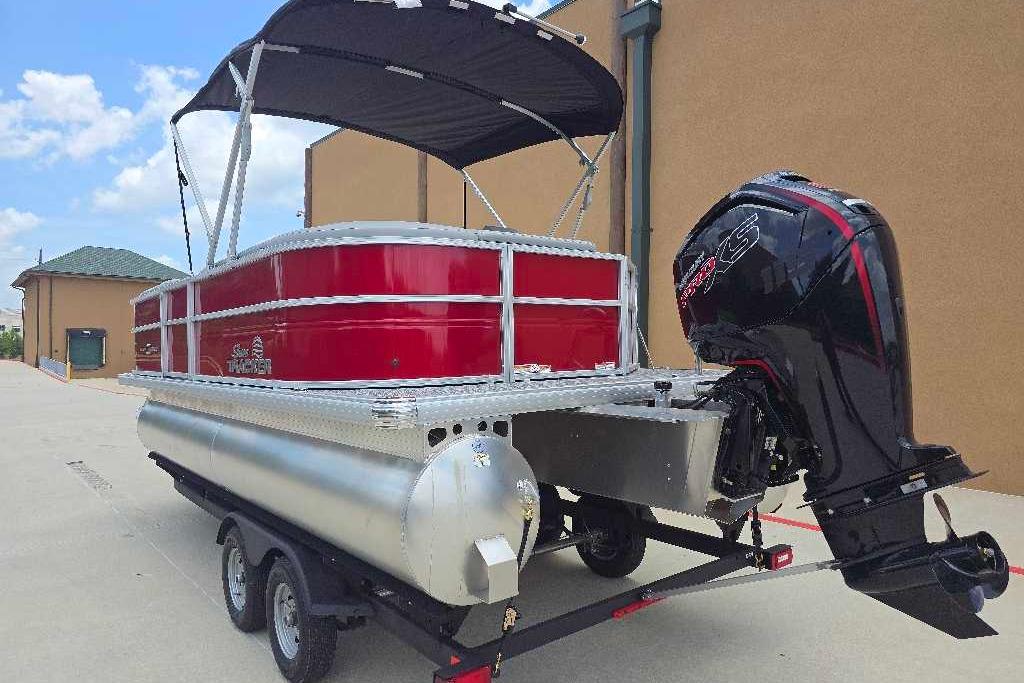 2026 Sun Tracker Party Barge 20 DLX pontoon boat with outboard motor on trailer.