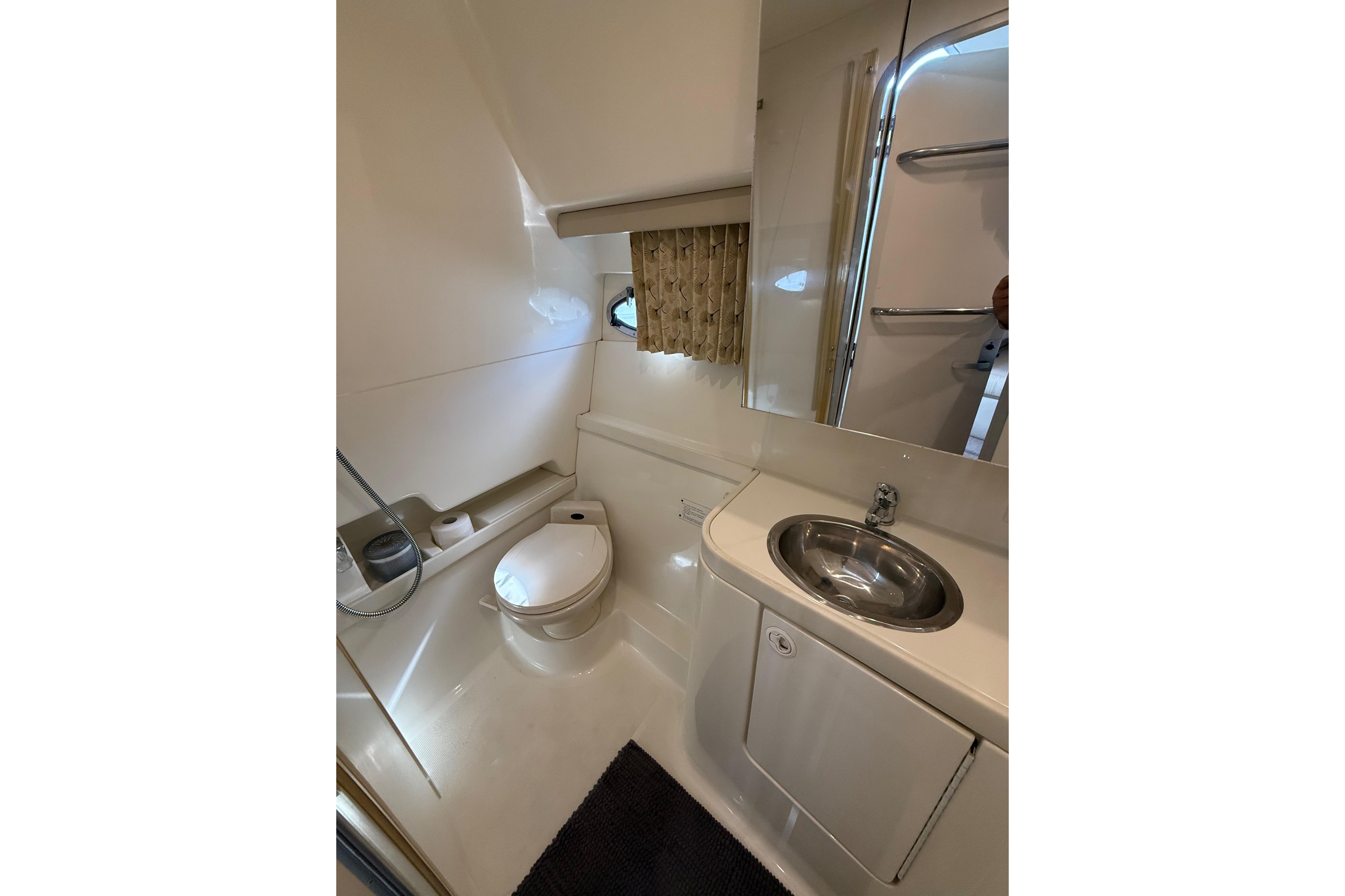1999 Formula 34 Performance Cruiser bathroom with toilet, sink, and mirror.
