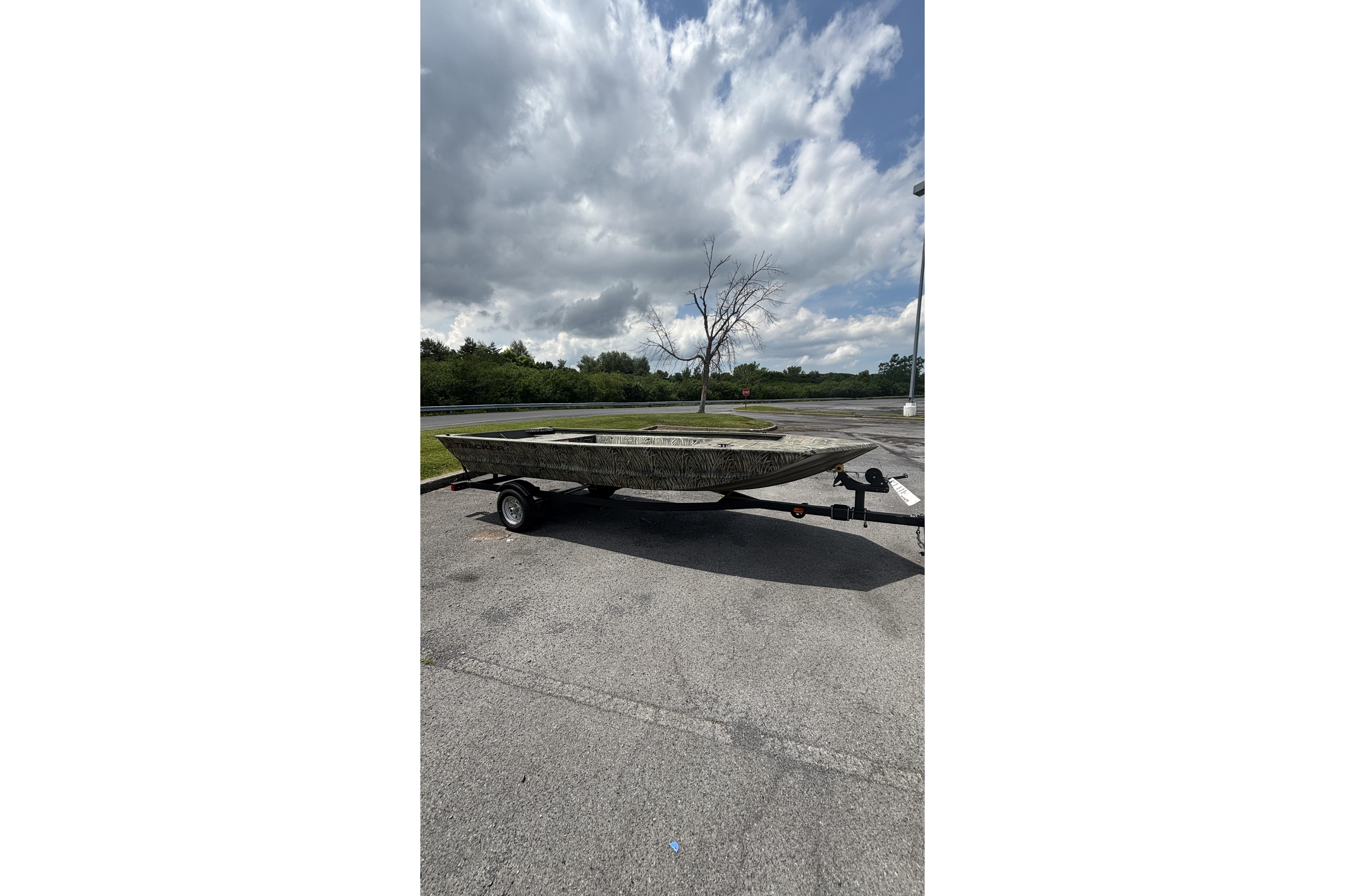 2026 Tracker Grizzly 1648 Utility boat on trailer under cloudy sky.