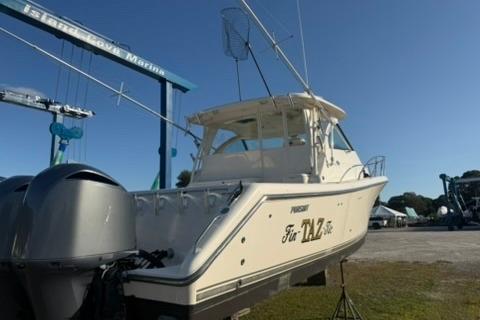 2010 Pursuit OS 375 Offshore boat docked at marina under clear blue sky.