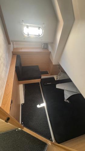 Cozy cabin interior of 2025 Nimbus T11 boat with seating and window.