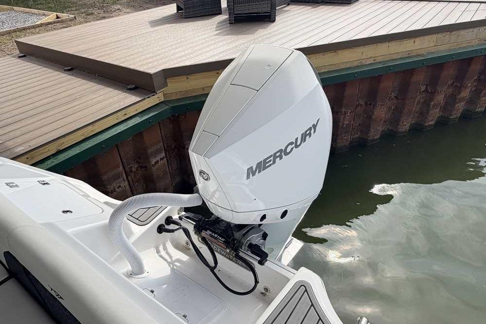 2024 Tidewater 232 LXF boat with Mercury outboard engine near dock.