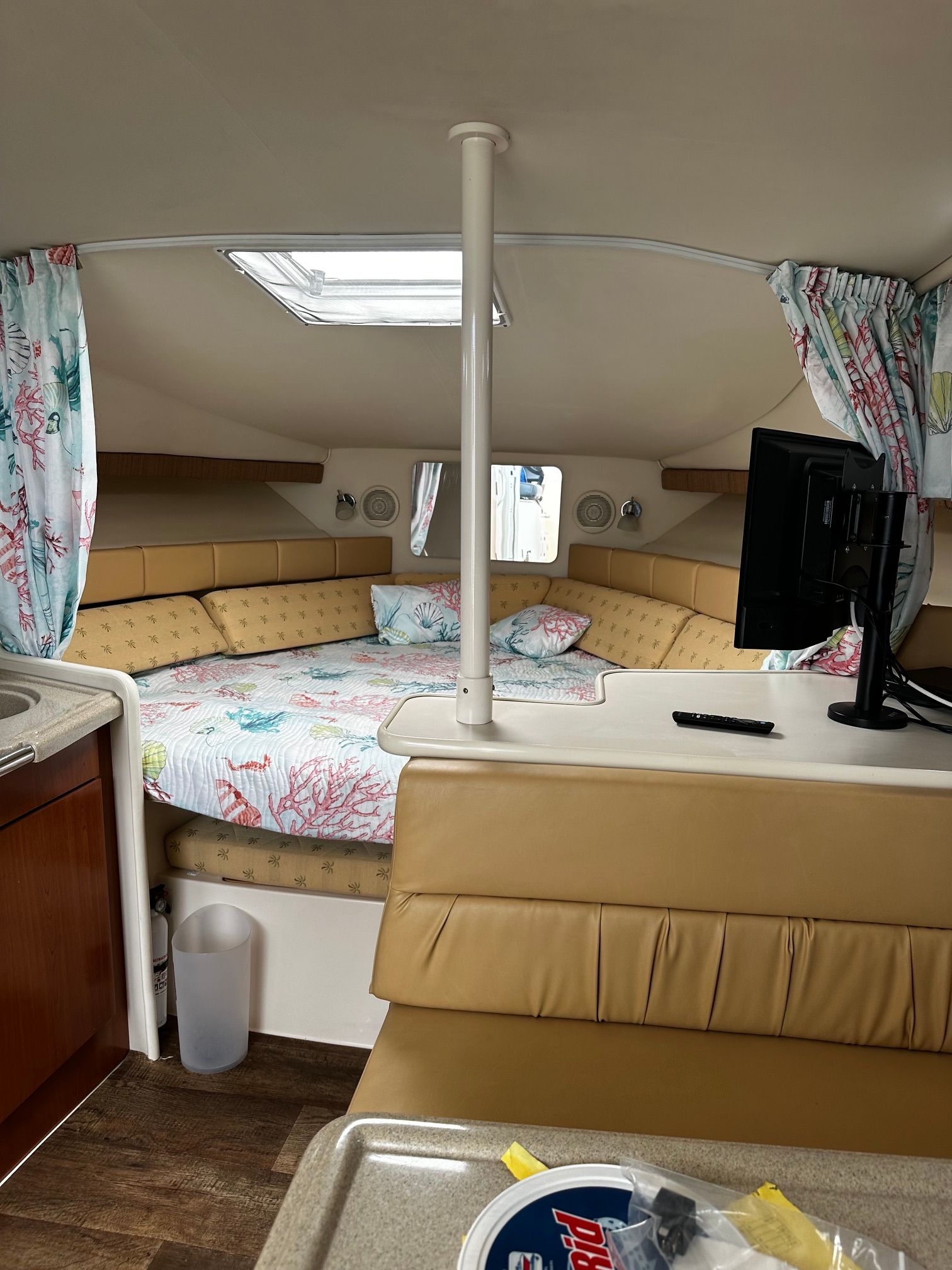Interior of a Wellcraft 330 Coastal with a cozy bed and TV.