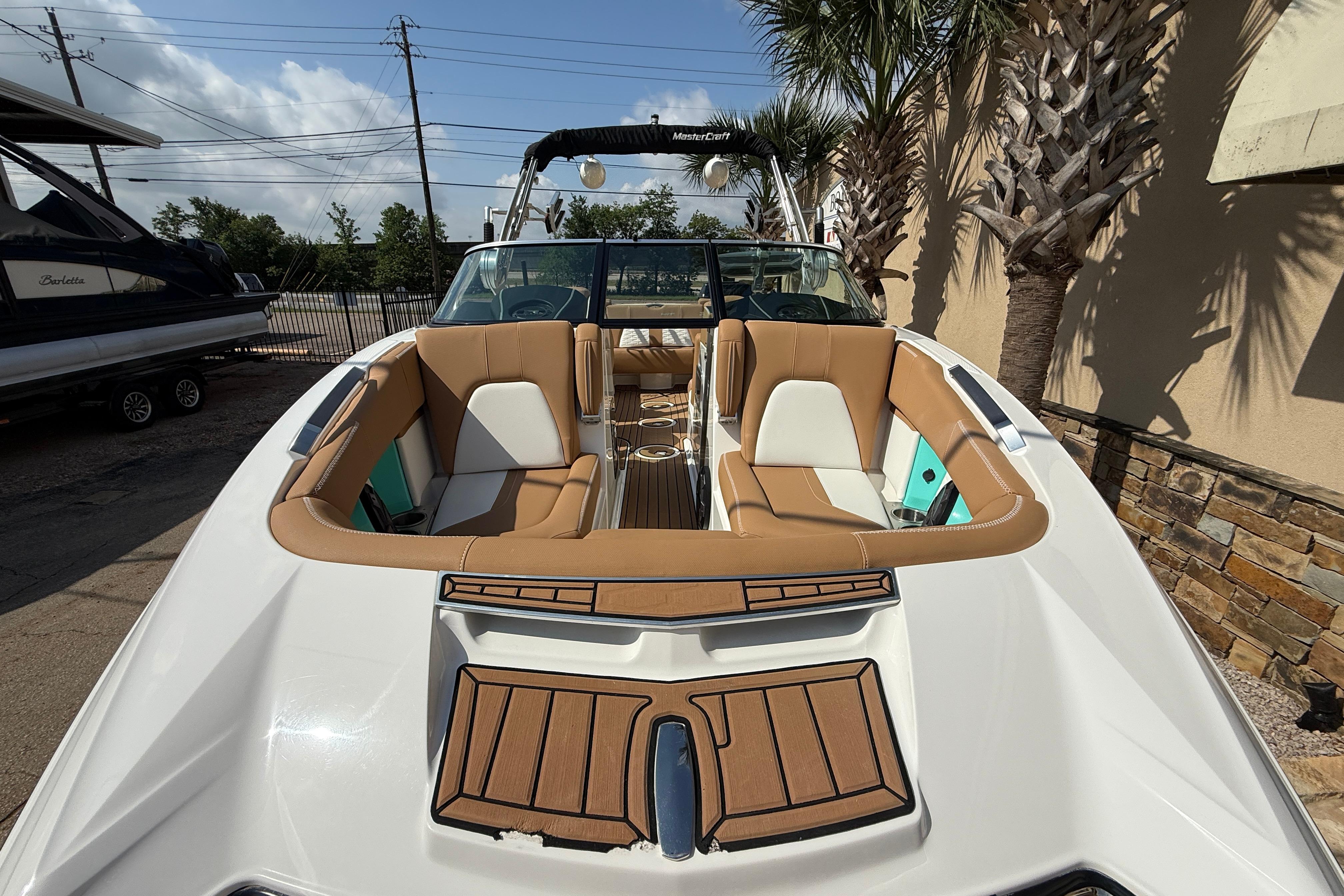 2020 MasterCraft X22 boat with tan seating and sleek design, docked outdoors.