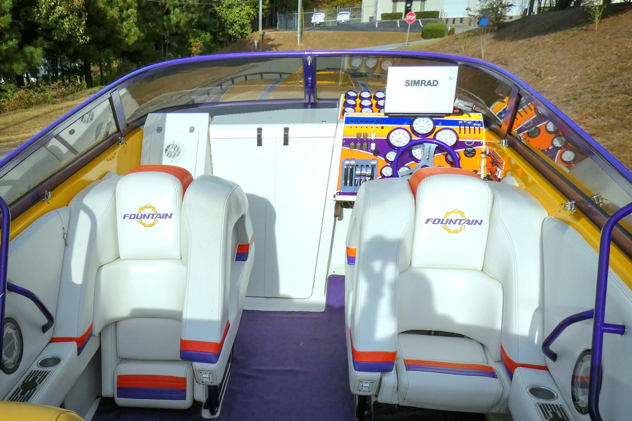 2006 Fountain 47 Lightning boat interior with white seats and colorful dashboard.
