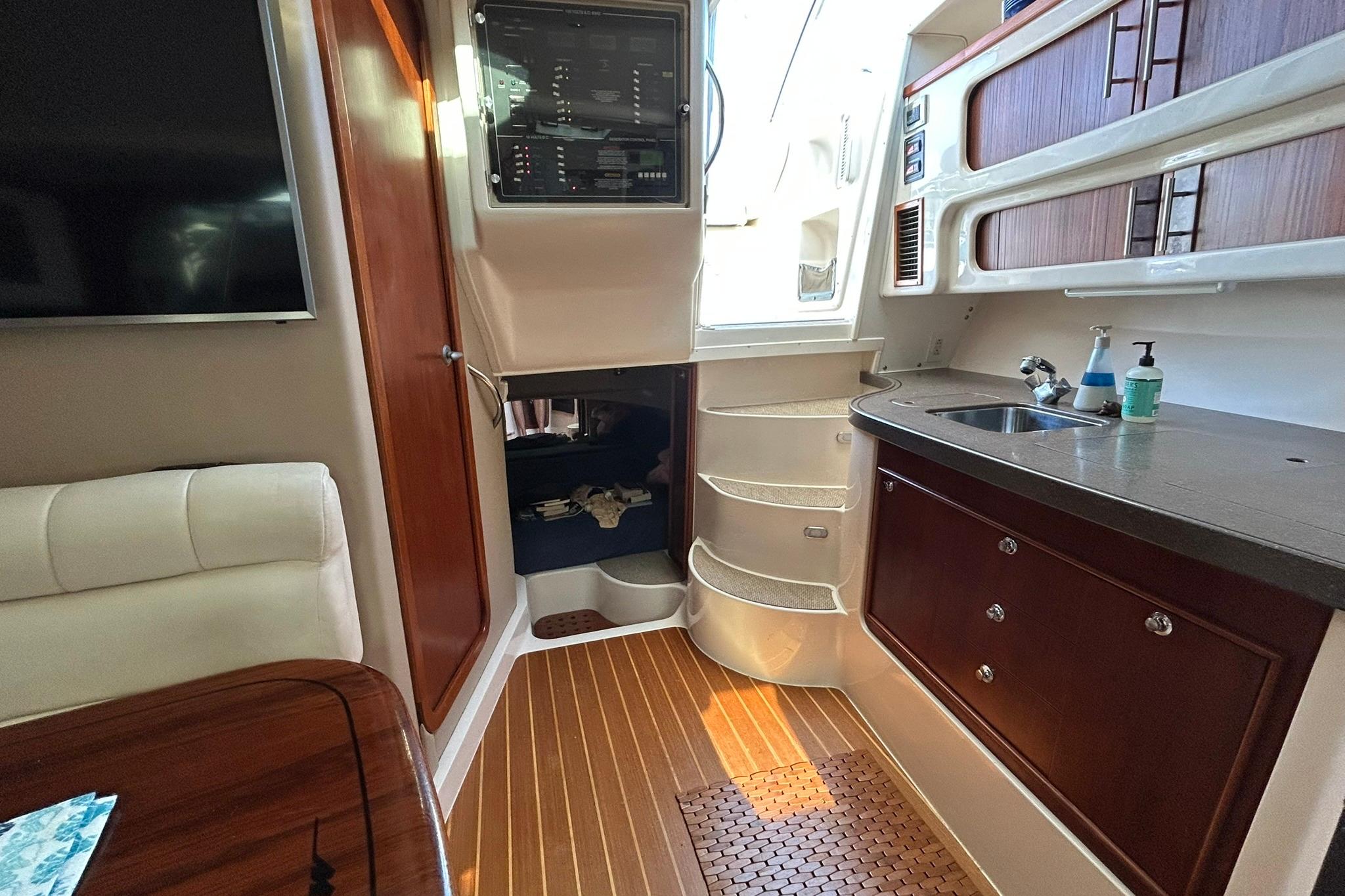 2007 Grady-White Express 360 interior with kitchenette, seating, and wooden flooring.
