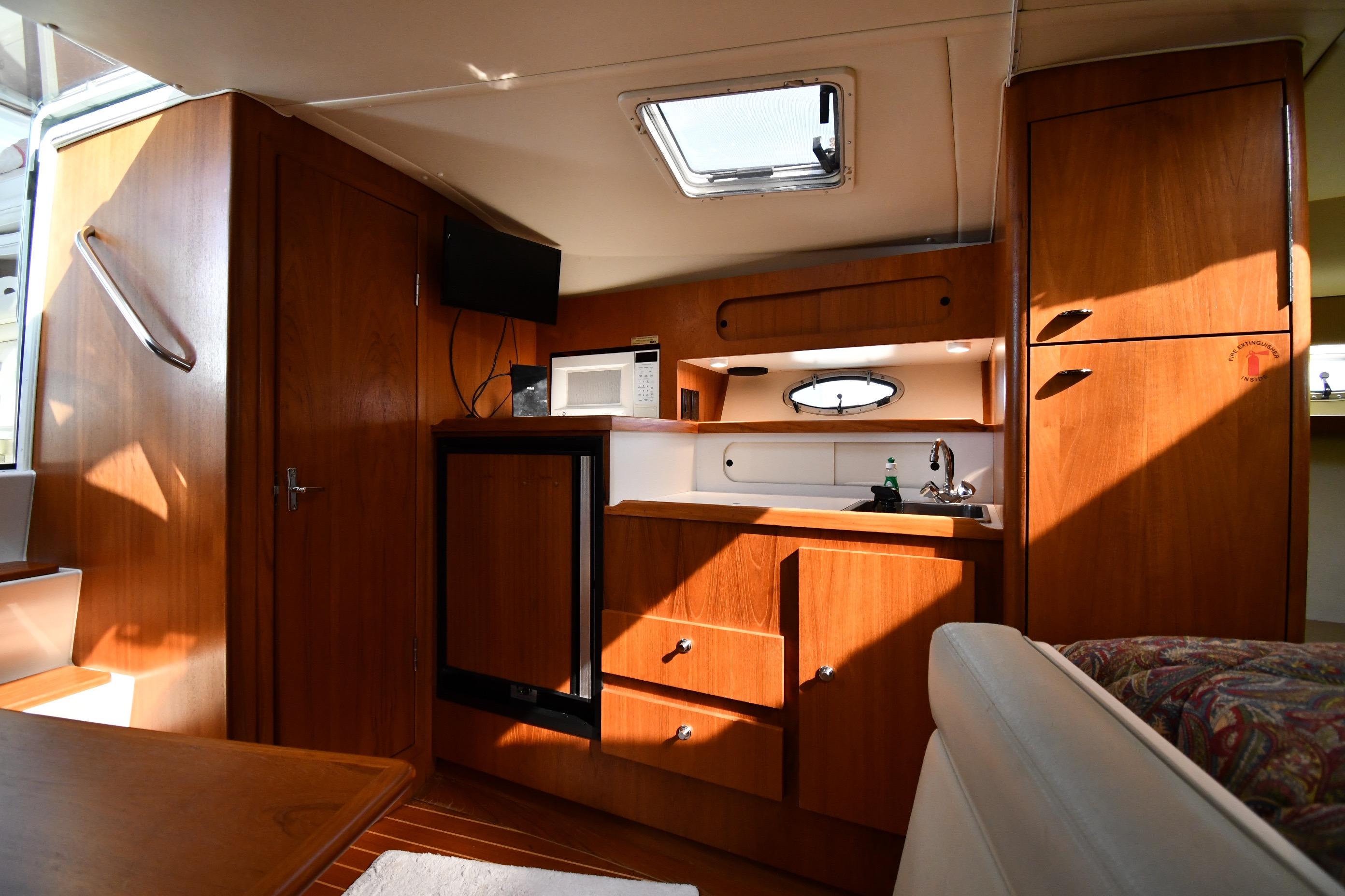 Interior of 1998 Tiara Yachts 3100 Open, featuring wooden cabinetry and compact kitchen amenities.