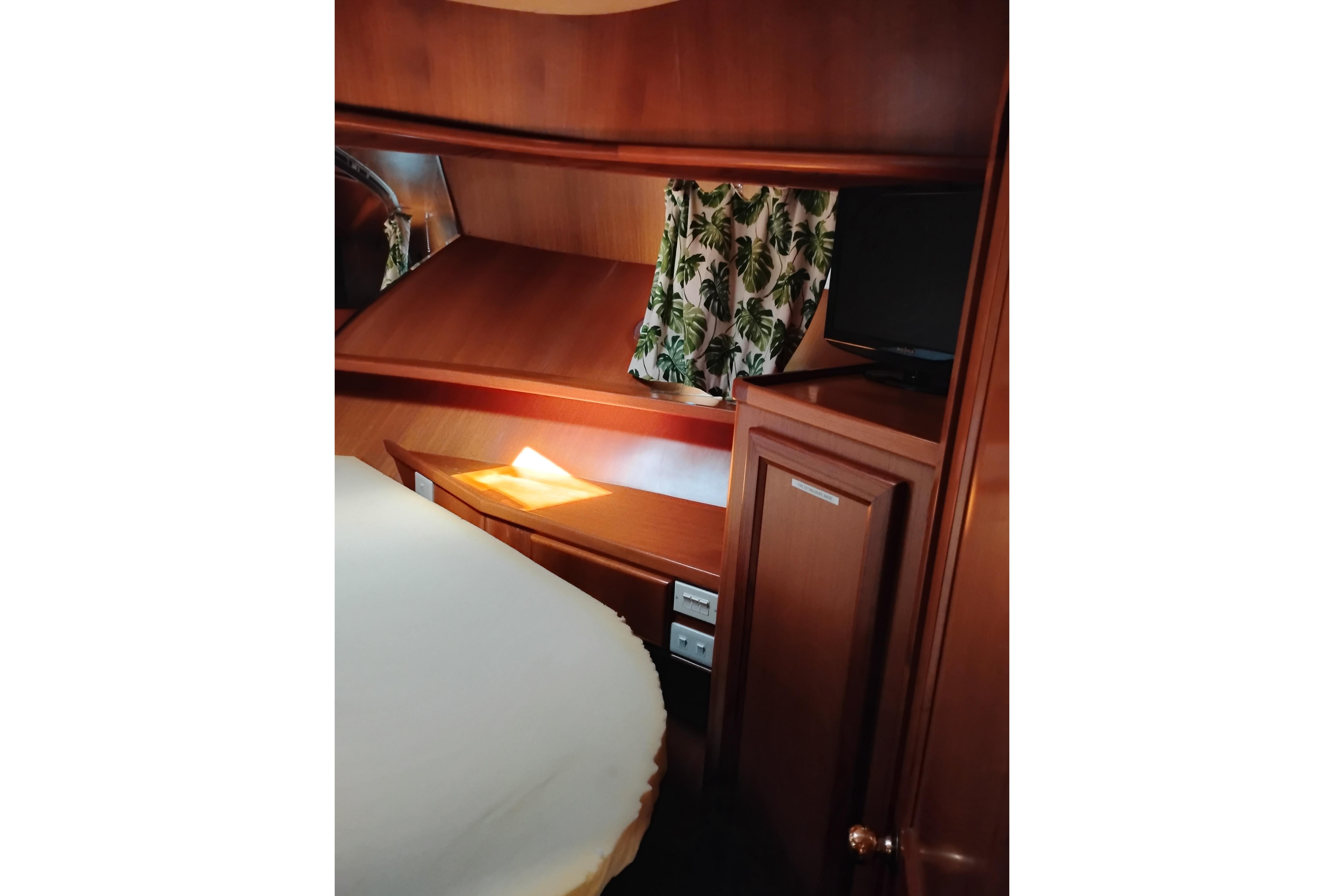 Cozy cabin interior of 1997 Symbol 50 Pilothouse with wood finish and tropical curtains.