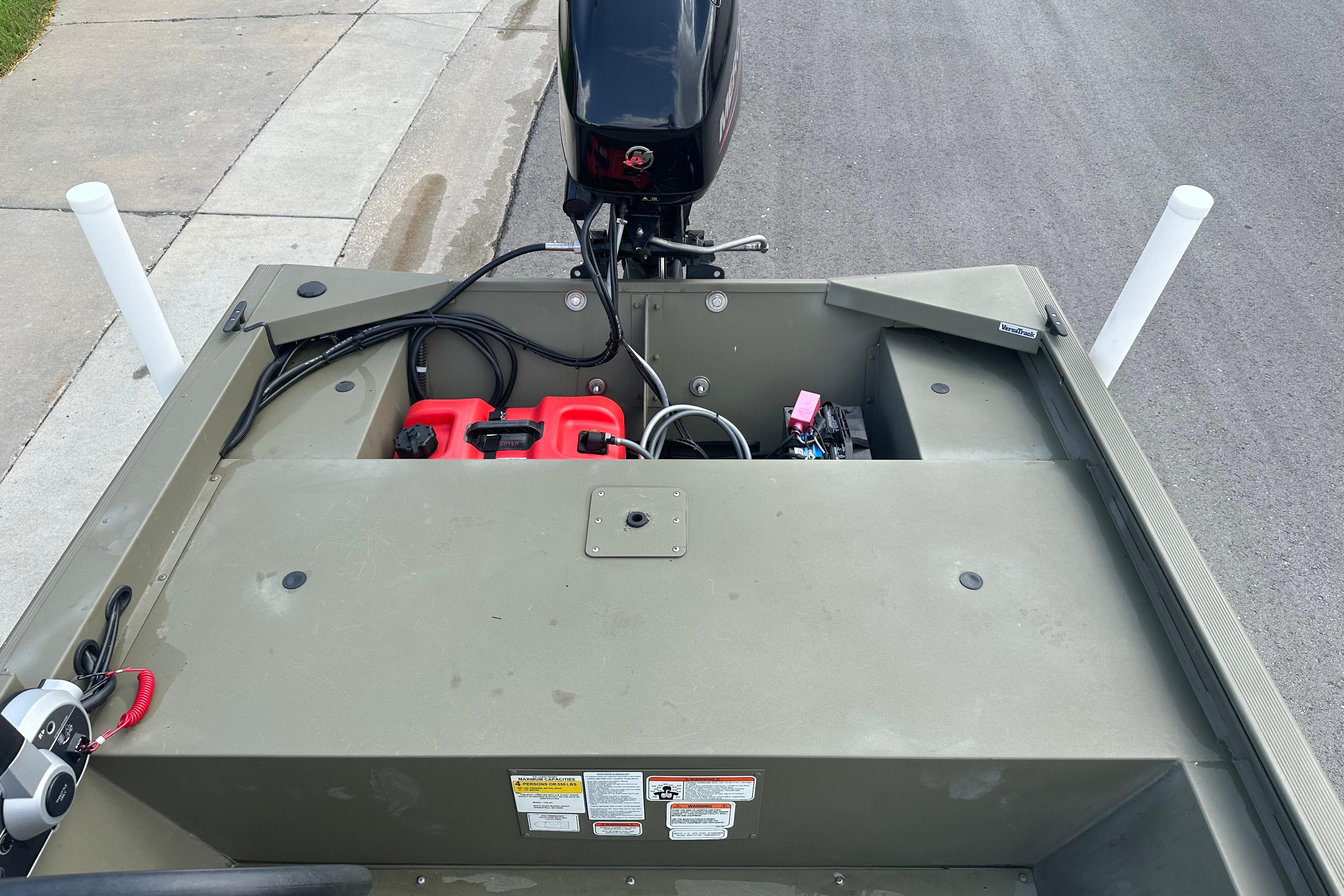2024 Tracker Grizzly 1648 SC boat with motor and equipment on a paved surface.