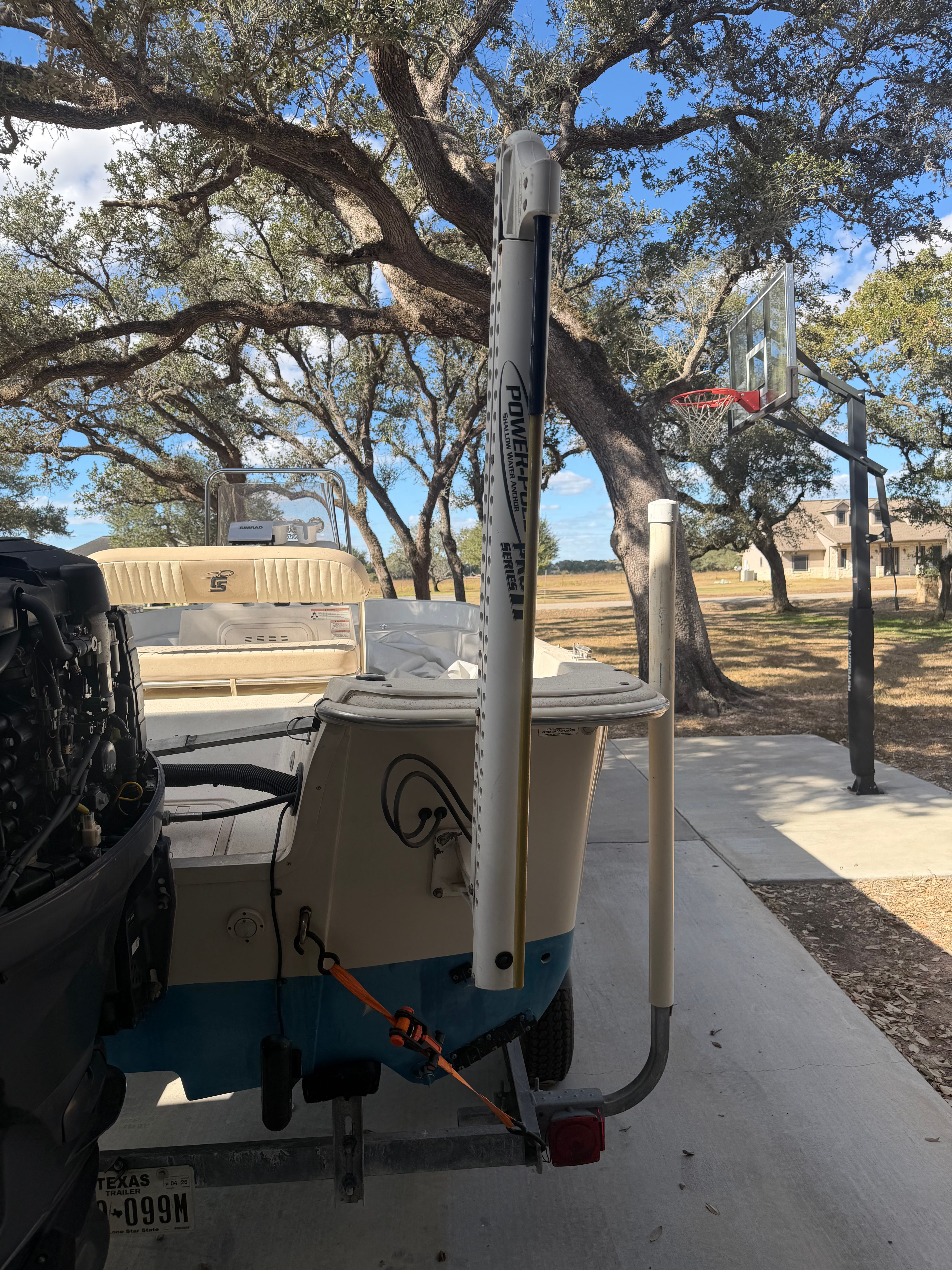 A 2016 Carolina Skiff 178 DLV boat is on a trailer in a driveway.