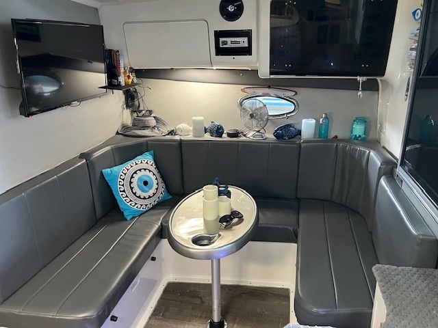 Interior of a 1989 Trojan 370 Express with gray upholstered seating, table, and decorations.