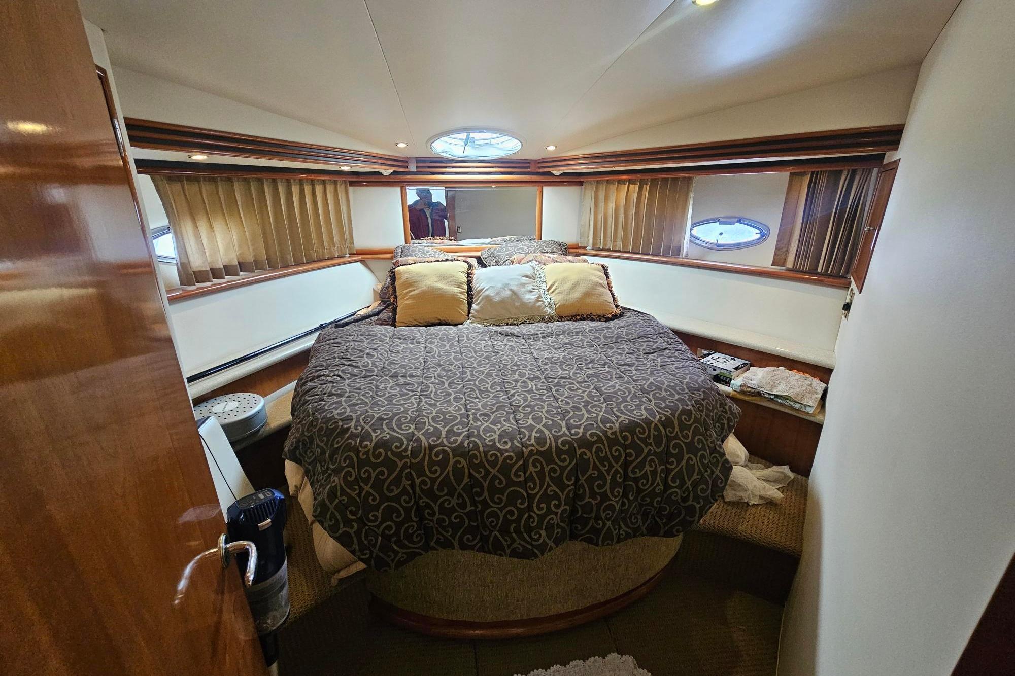 Luxurious bedroom interior of 2002 Carver 450 Voyager Pilothouse yacht with elegant bedding.